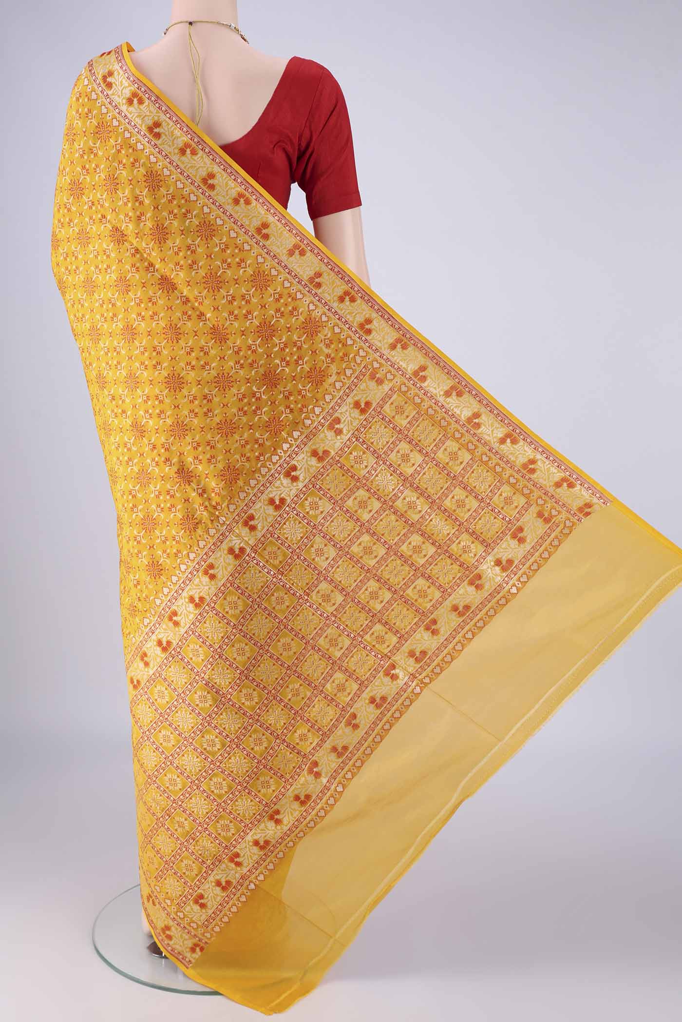 Flat view of Yellow Banarasi Silk Saree with Zari And Thread Butta on the body and Zari And Thread Border. 