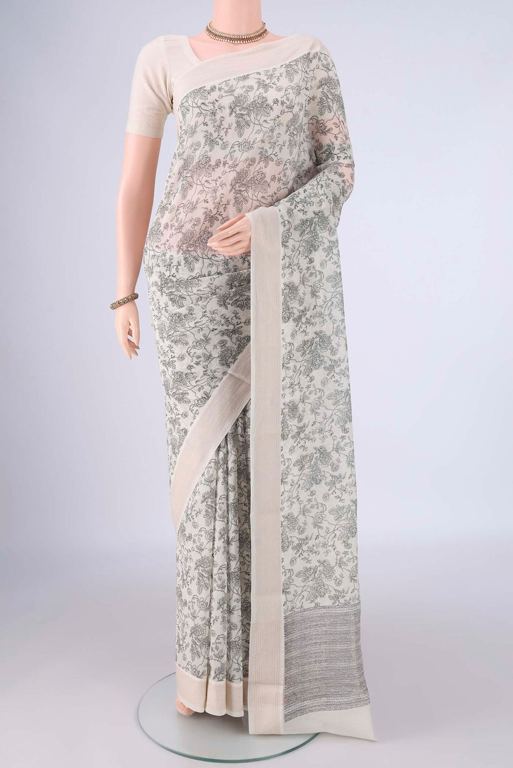 Off White Chanderi Silk Cotton Saree with Printed design on the body and Thread Border.  displayed on a mannequin