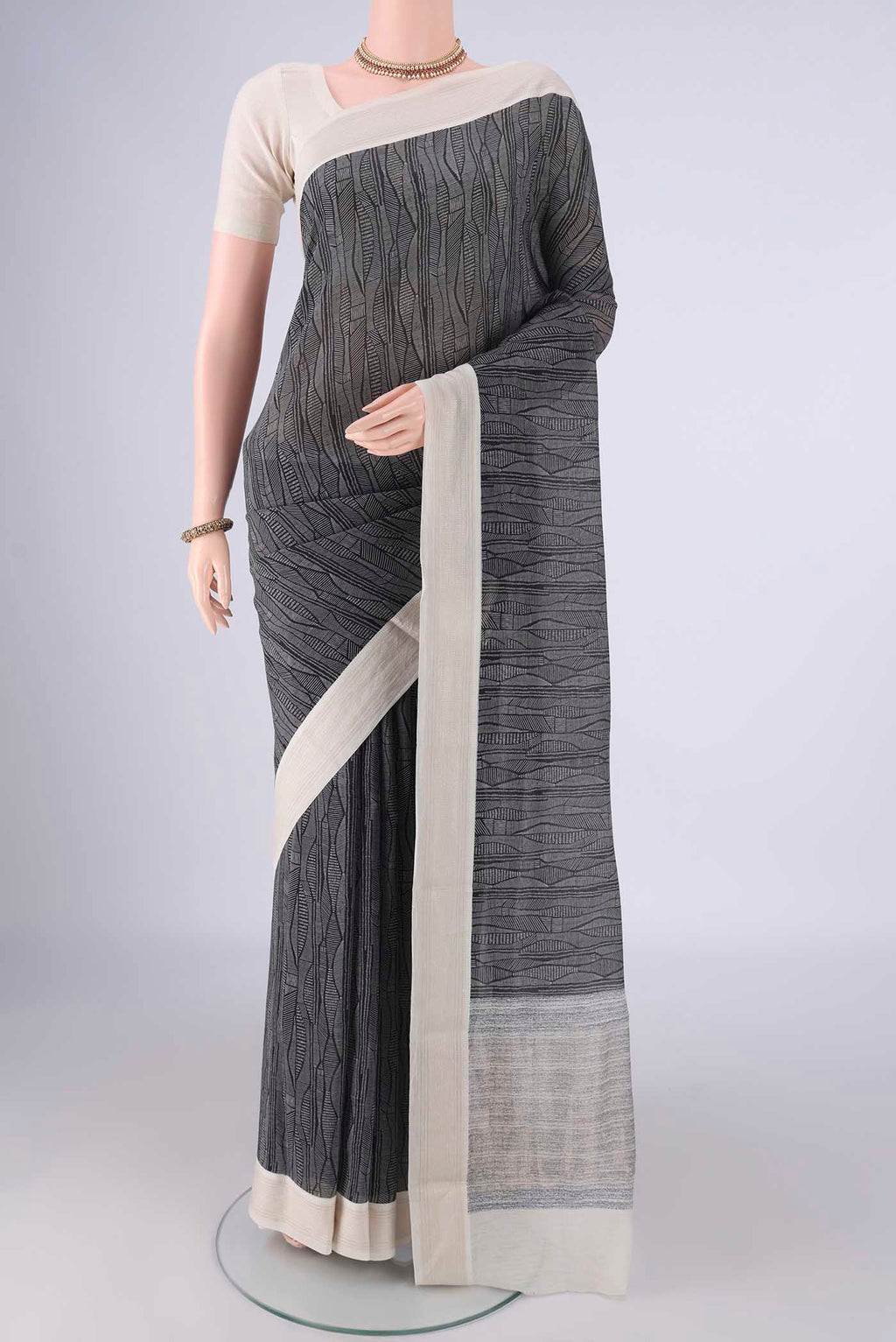 Black Chanderi Silk Cotton Saree with Printed design on the body and Thread Border.  displayed on a mannequin