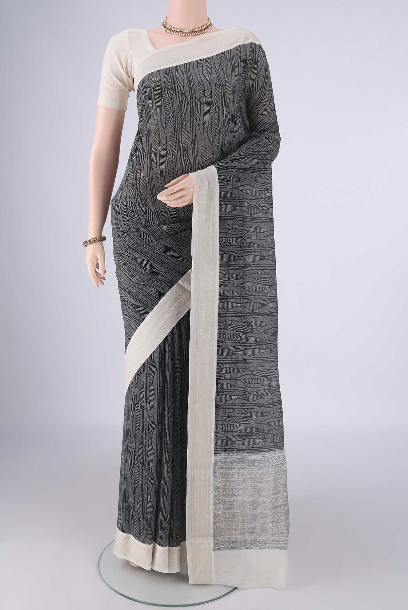 Black Chanderi Silk Cotton Saree with Printed design on the body and Thread Border.  displayed on a mannequin