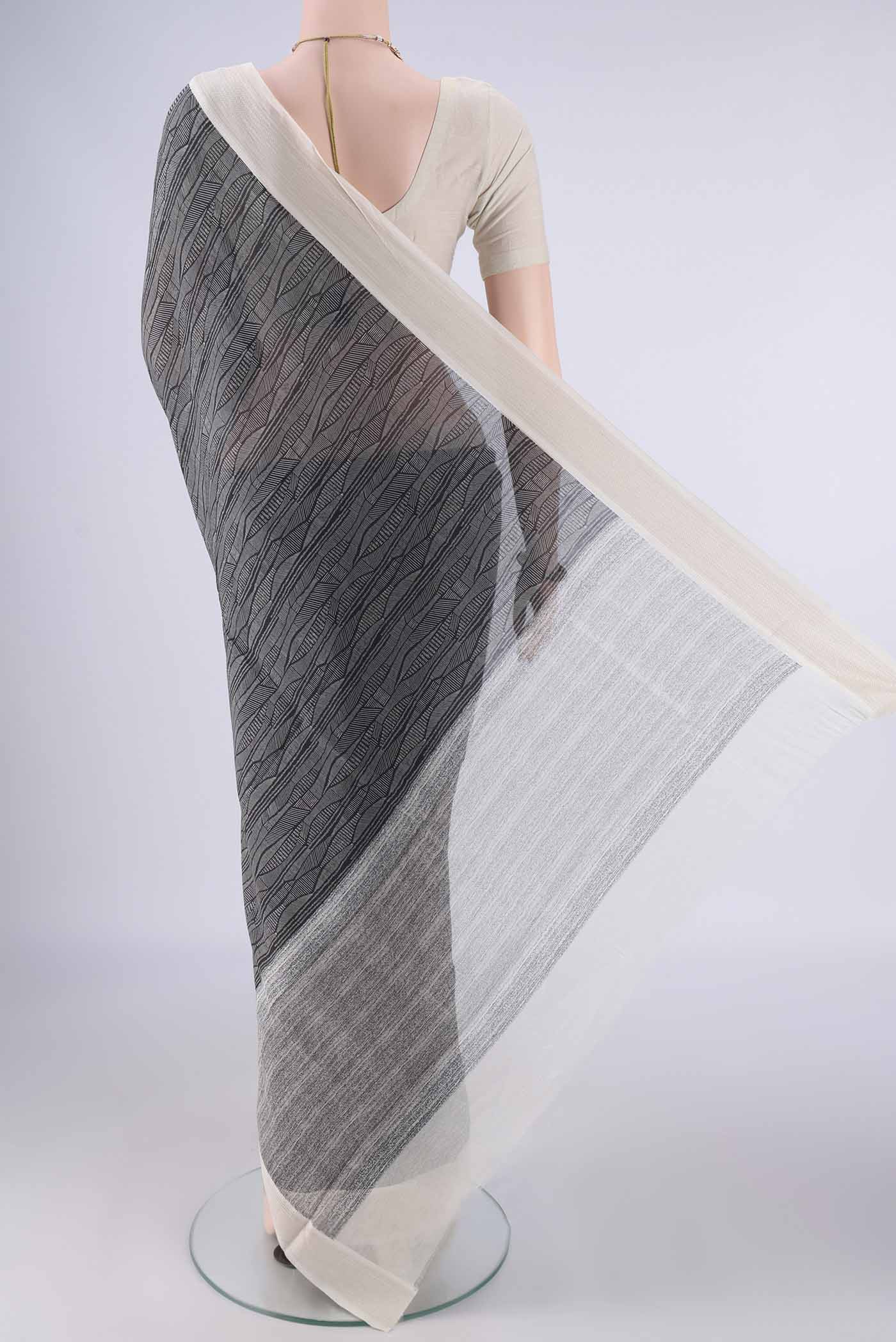 Flat view of Black Chanderi Silk Cotton Saree with Printed design on the body and Thread Border. 