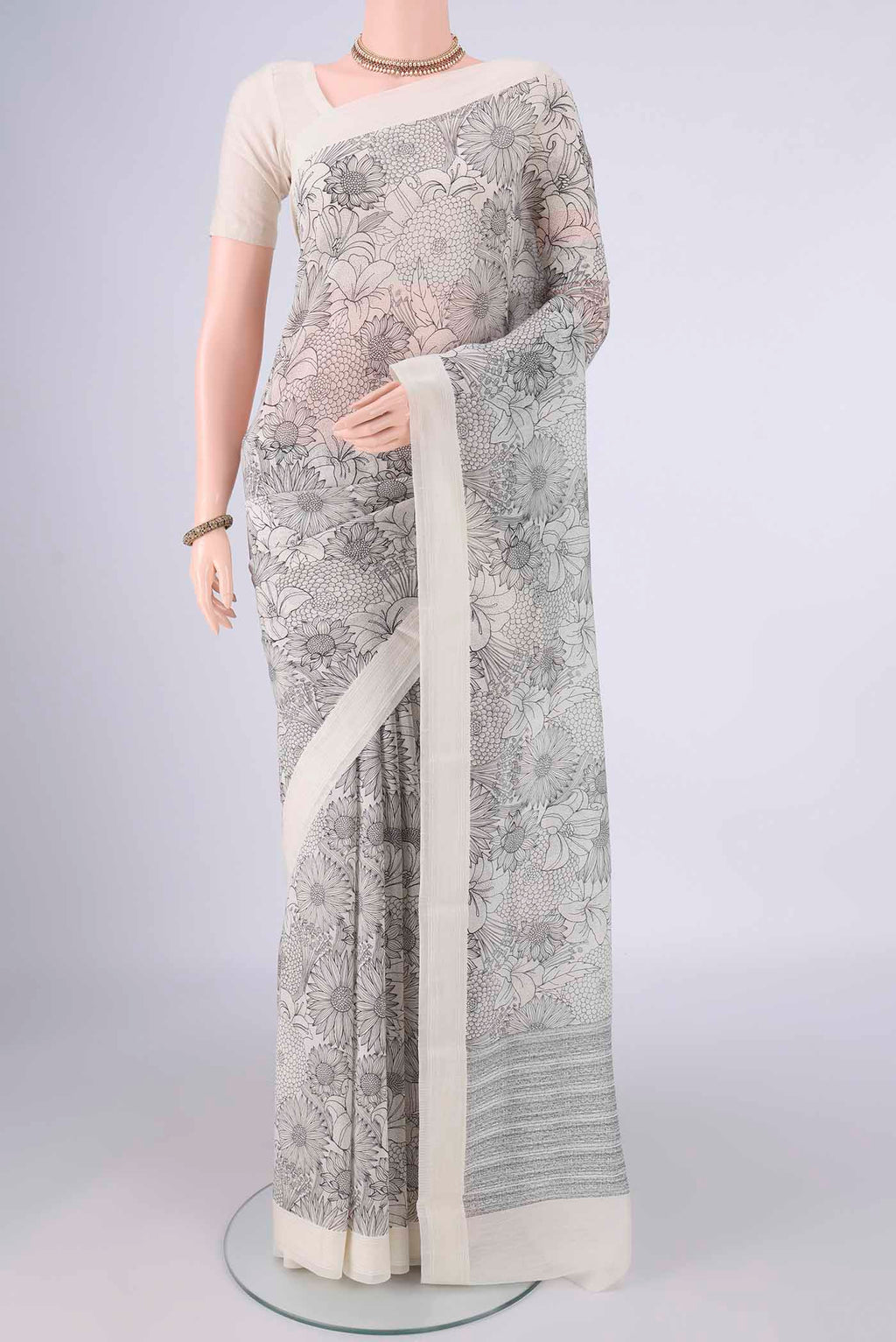 Off White Chanderi Silk Cotton Saree with Floral Print on the body and Thread Border.  displayed on a mannequin