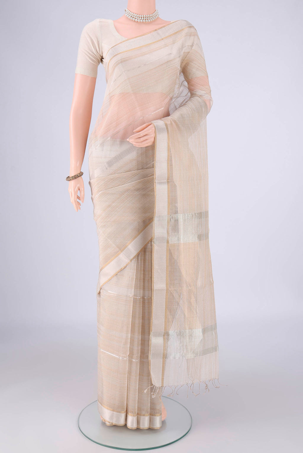 Off White Maheshwari Silk Cotton Saree with Stripes on the body and Zari Border.  displayed on a mannequin