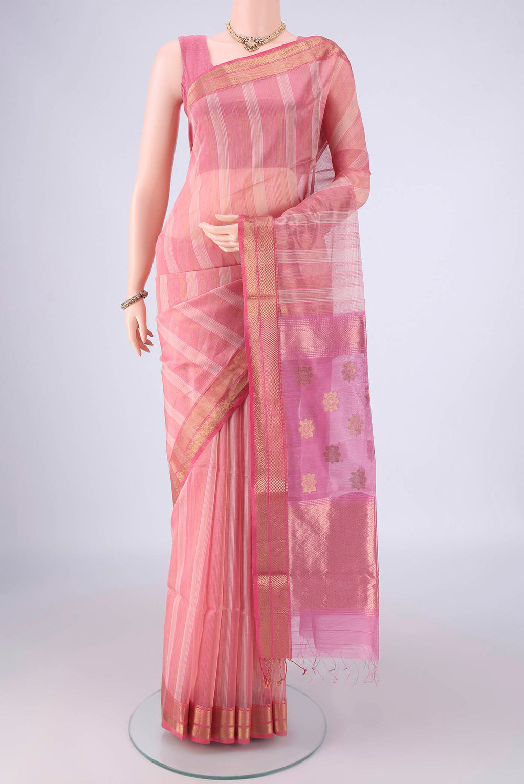 Peach Maheshwari Silk Cotton Saree with Stripes on the body and Zari Border.  displayed on a mannequin