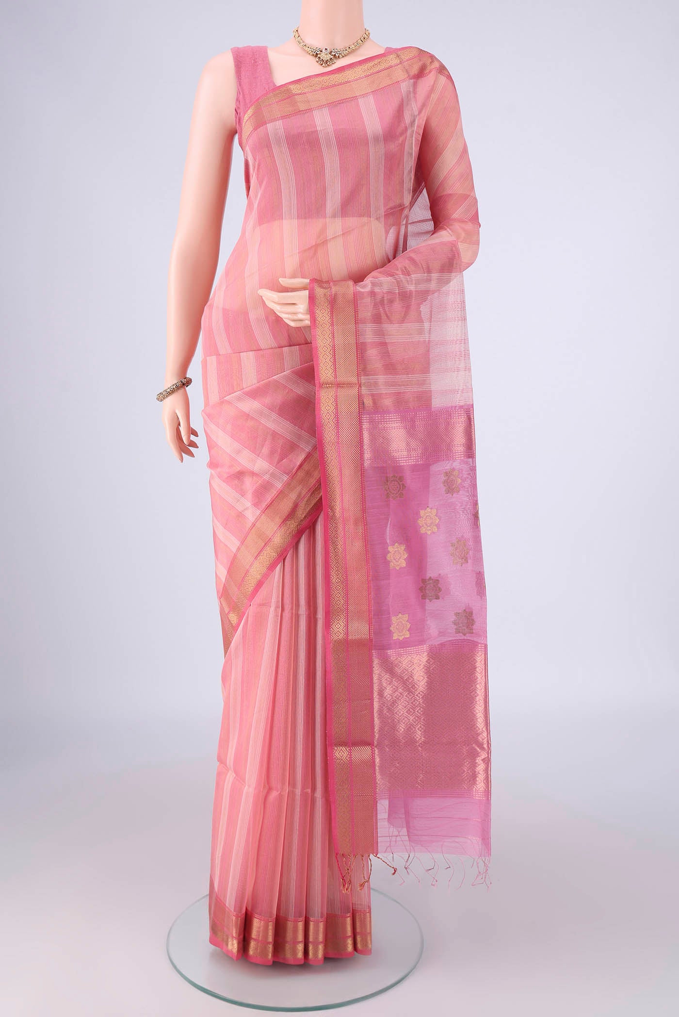 Peach Maheshwari Silk Cotton Saree with Stripes on the body and Zari Border.  displayed on a mannequin