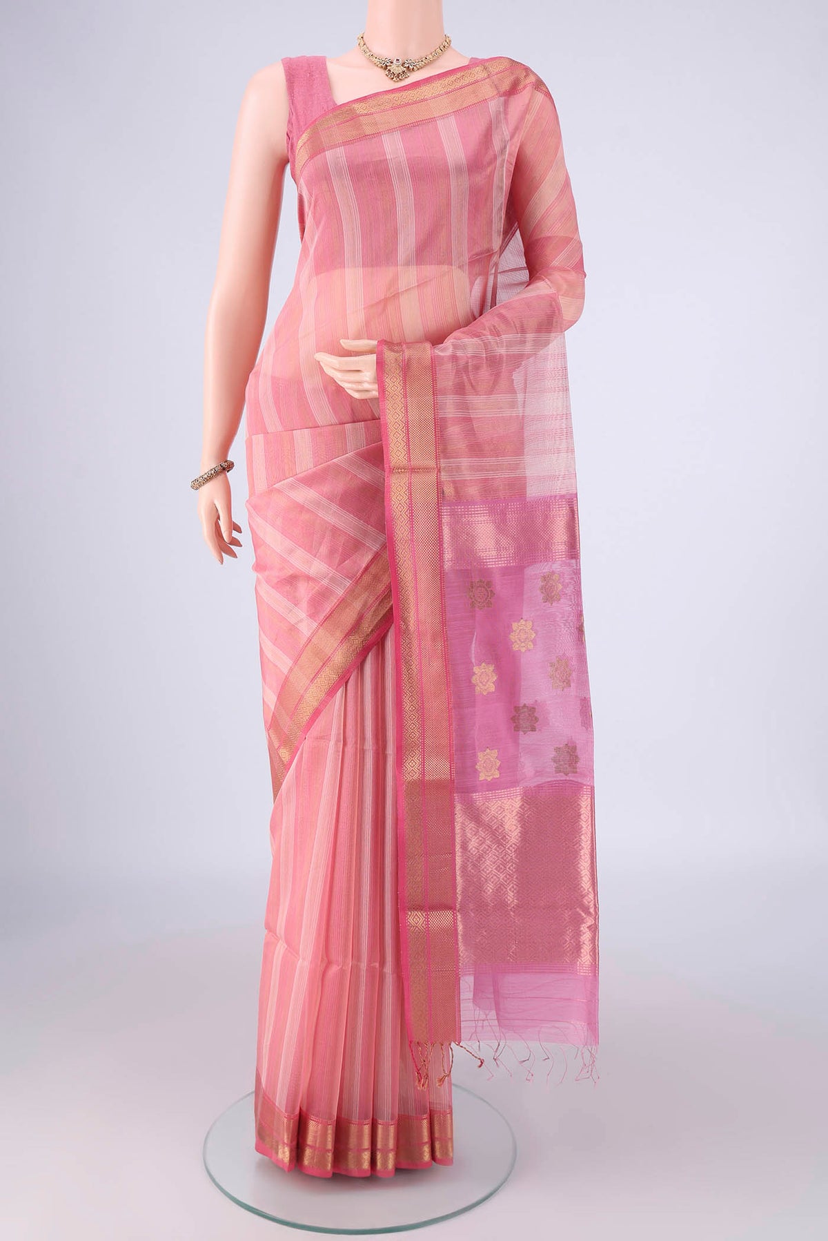 Peach Maheshwari Silk Cotton Saree with Stripes on the body and Zari Border.  displayed on a mannequin