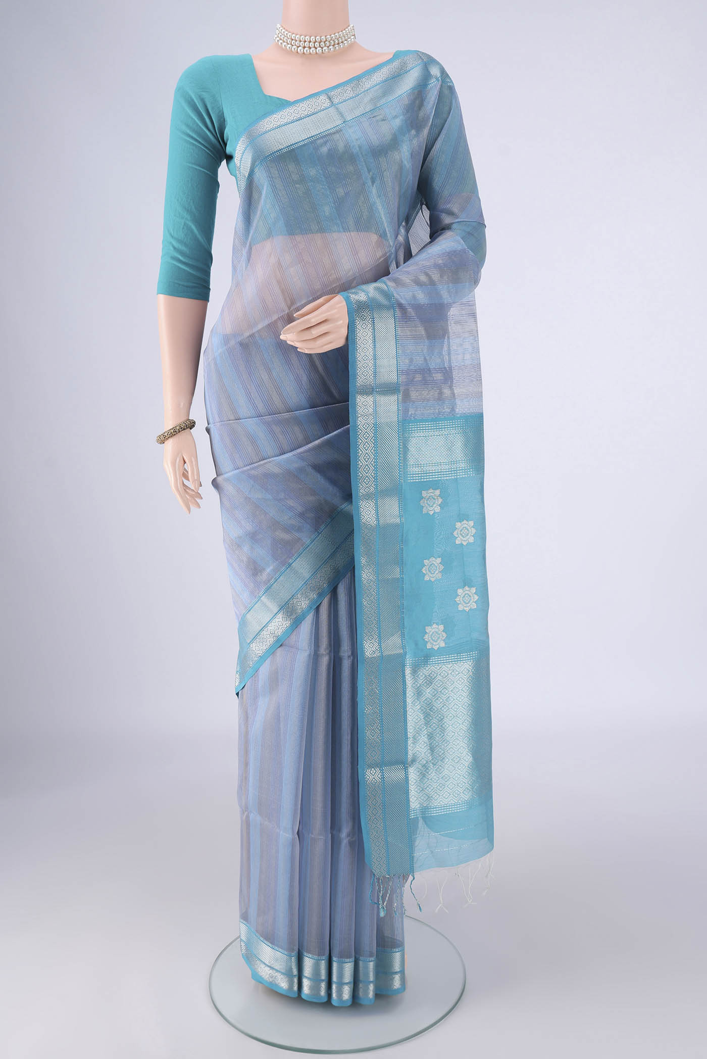 Sky Blue Maheshwari Silk Cotton Saree with Stripes on the body and Zari Border.  displayed on a mannequin
