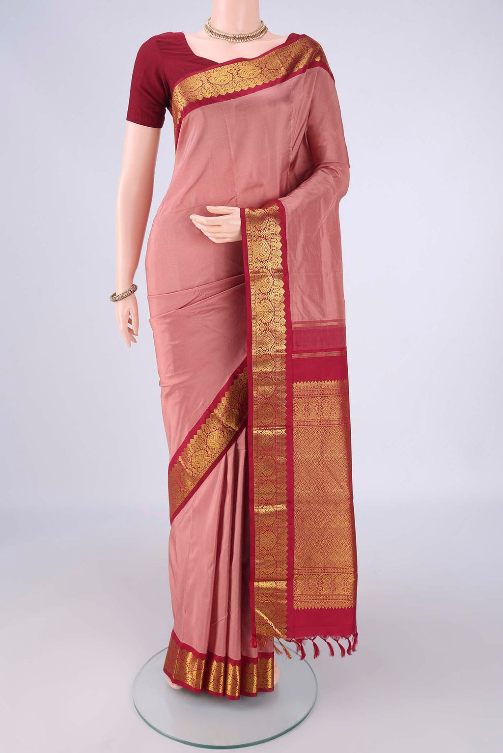 Coral Dual Tone Kanjivaram Silk Saree with Plain Body and Zari Border.  displayed on a mannequin