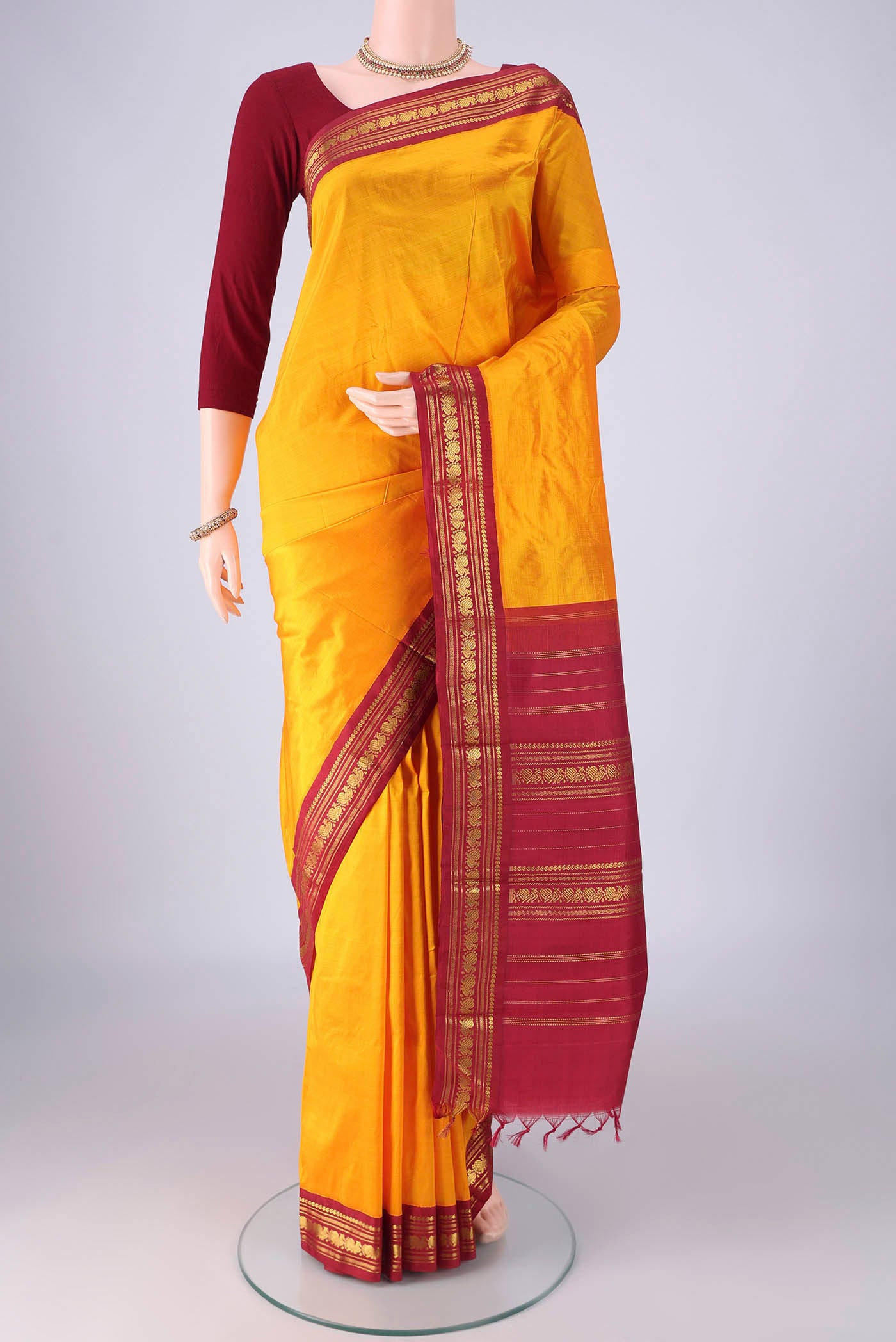 Pure Silk Pure Zari Yellow Kanchipuram Saree with Plain Body and Zari Border.  displayed on a mannequin