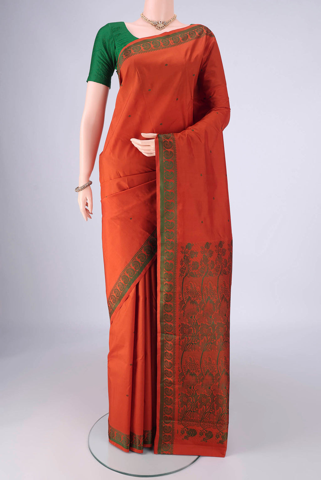 Rust Kanchipuram Silk Saree with Thread Butta on the body and Thread Border.  displayed on a mannequin