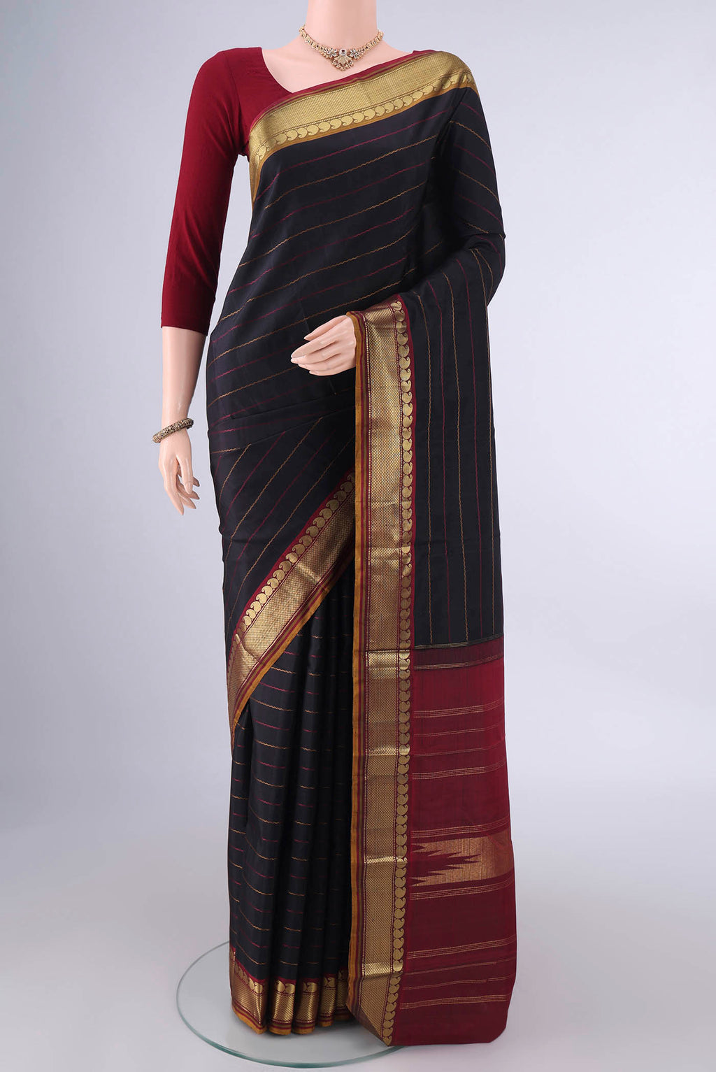 Pure Silk Black Kanchipuram Saree with Veldhari on the body and Zari Border.  displayed on a mannequin