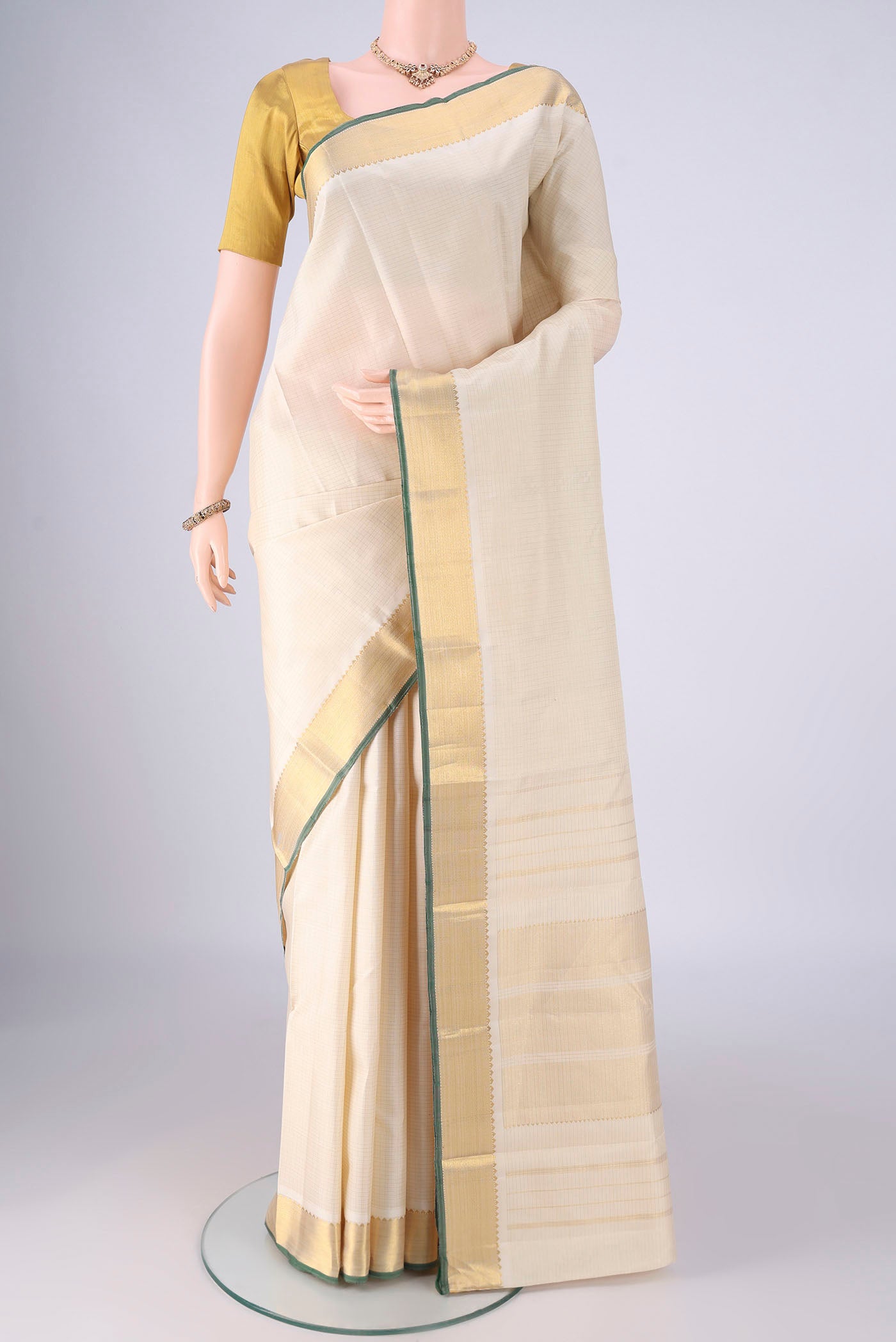 Off White Kanchipuram Silk Saree with Checked design on the body and Zari Border.  displayed on a mannequin