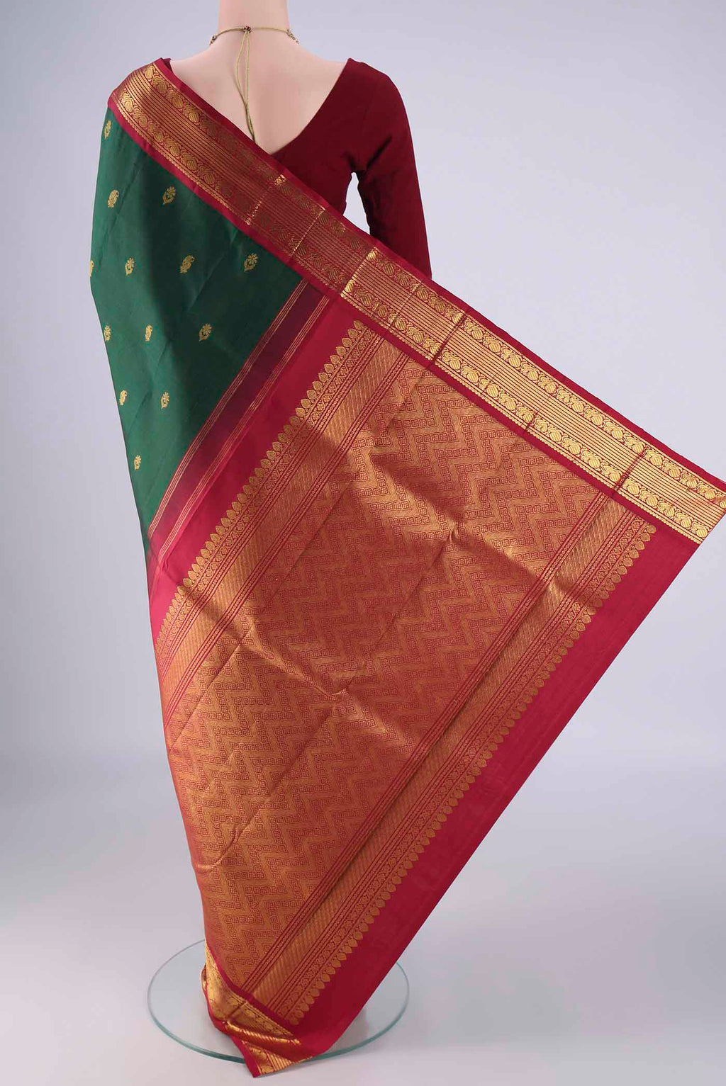 Flat view of Green Kanchipuram Silk Saree with Zari Butta on the body and Zari Border. 