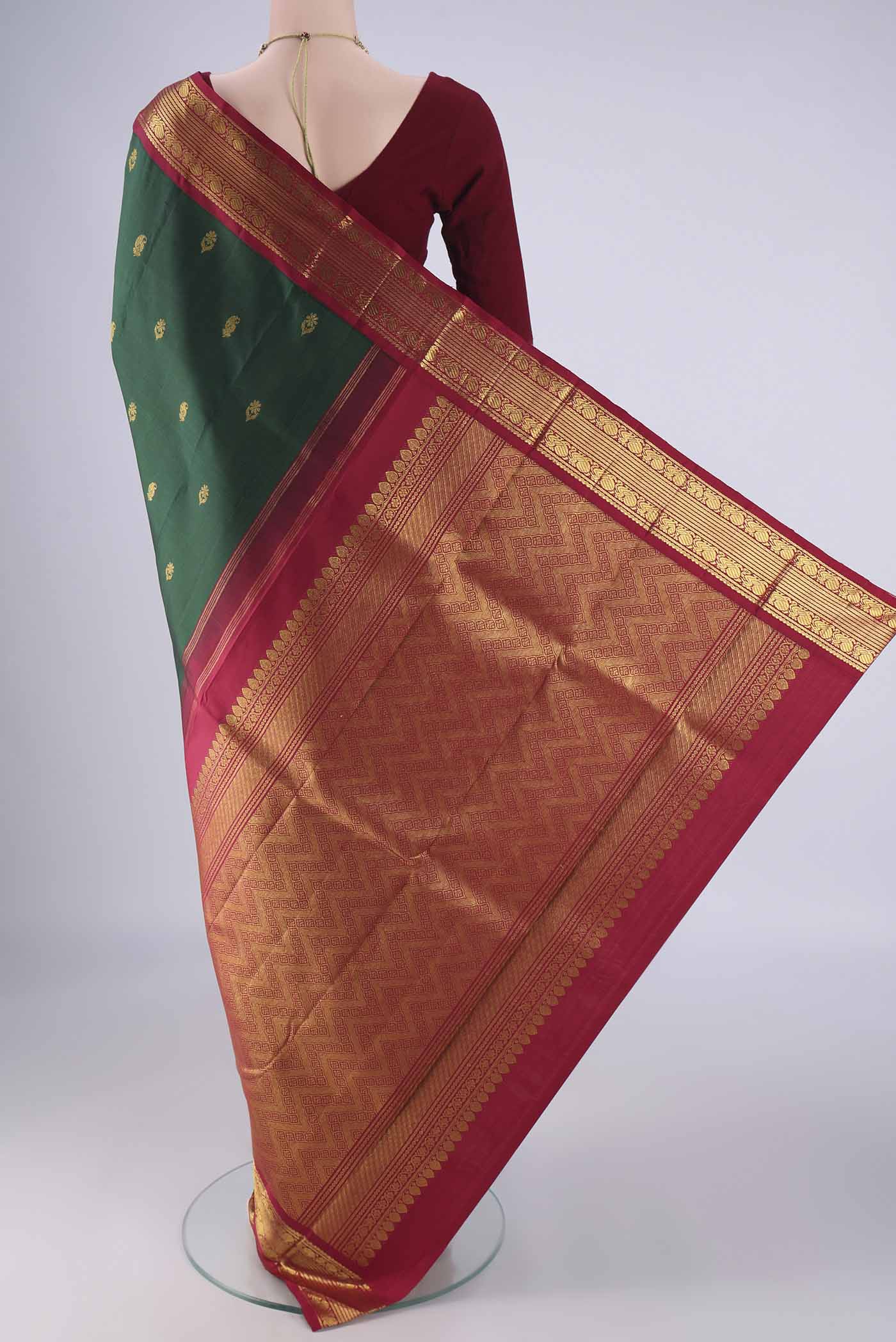 Flat view of Green Kanchipuram Silk Saree with Zari Butta on the body and Zari Border. 