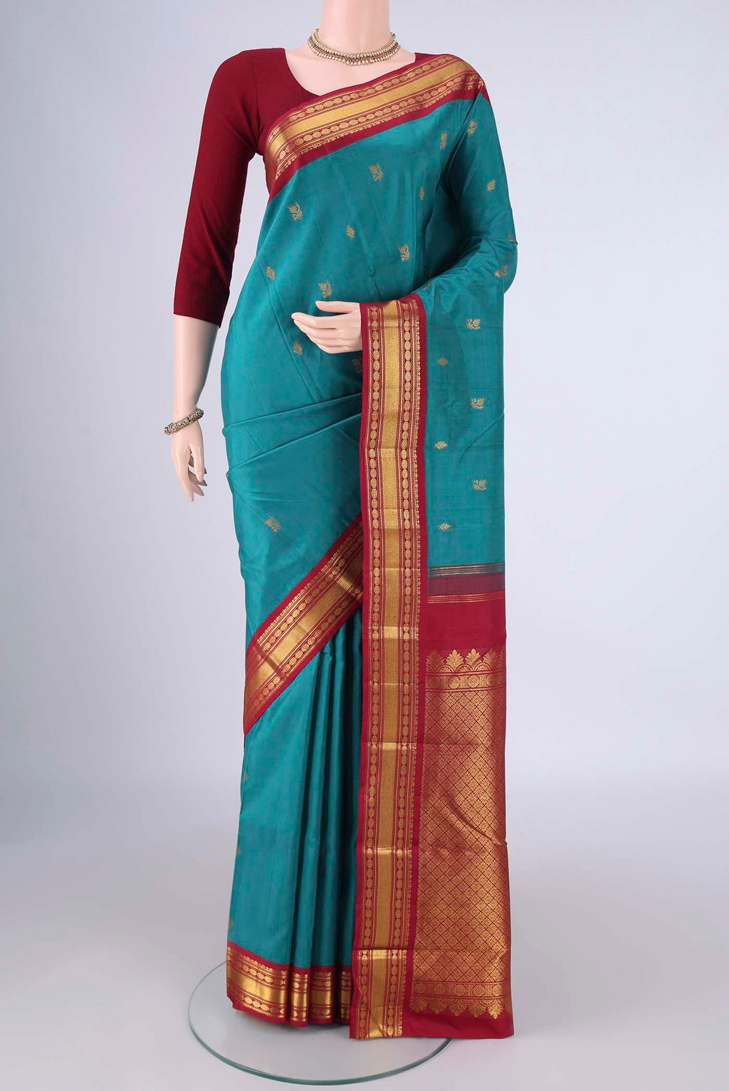 Blue Kanchipuram Silk Saree with Zari Butta on the body and Zari Border.  displayed on a mannequin