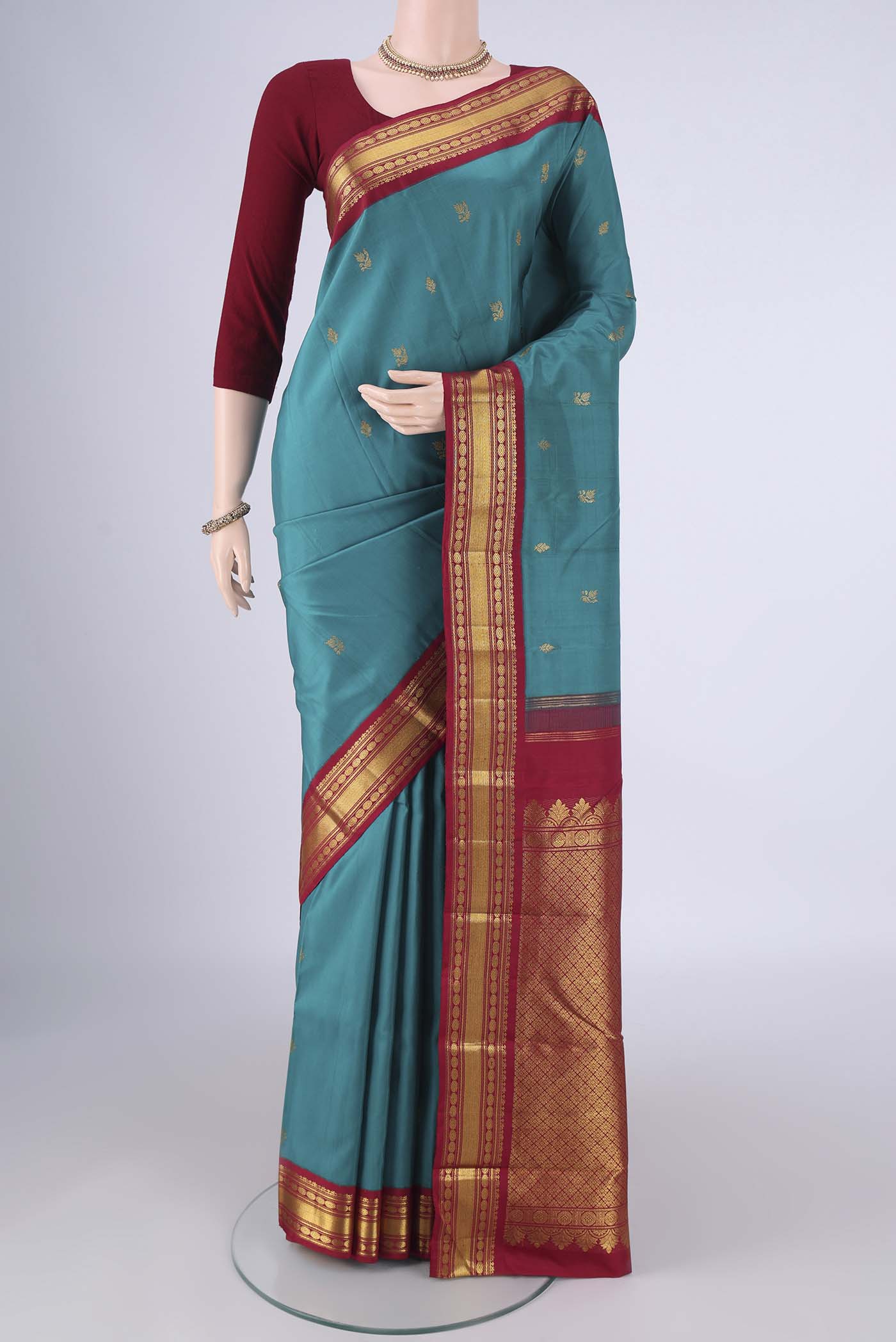 Blue Kanchipuram Silk Saree with Zari Butta on the body and Zari Border.  displayed on a mannequin