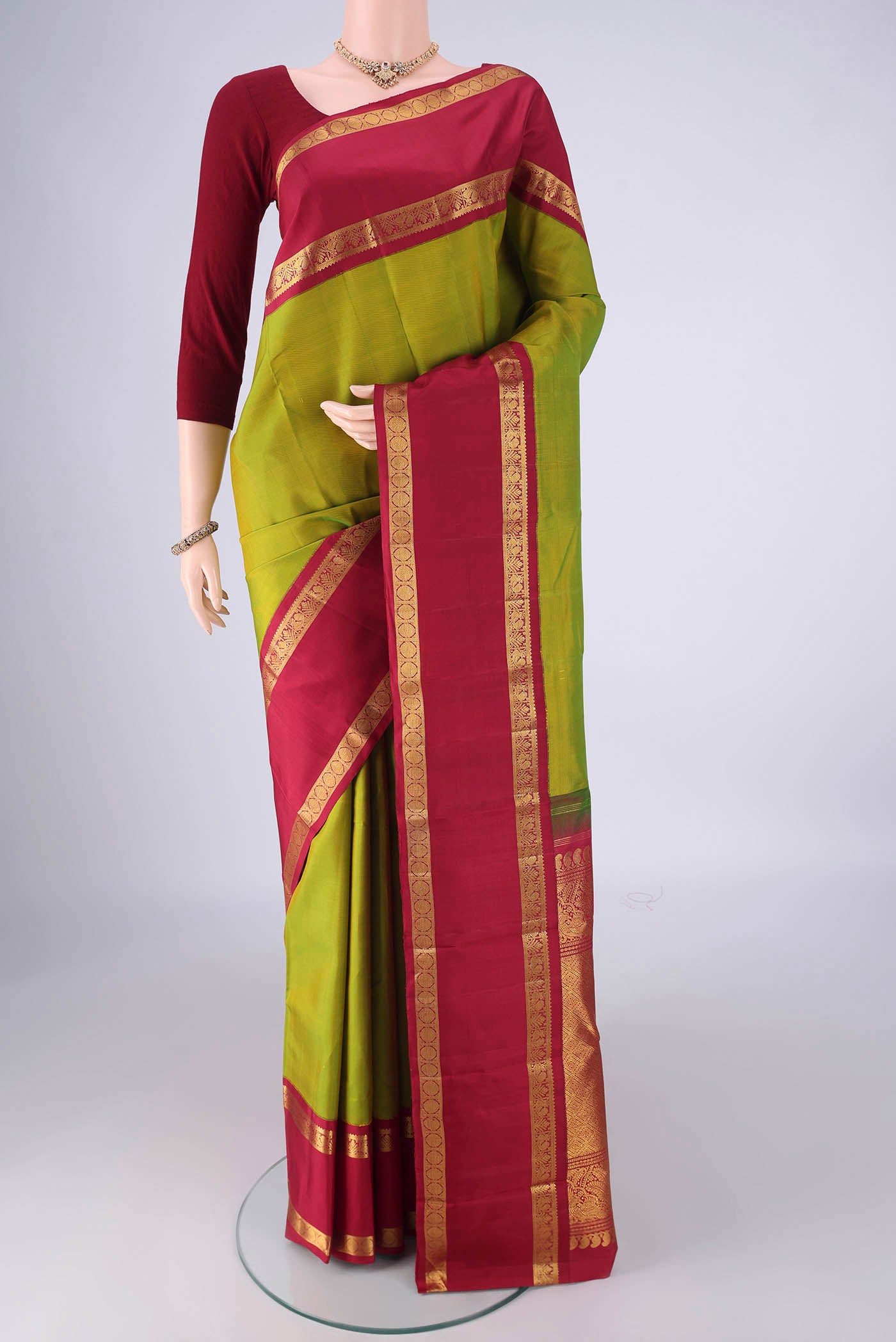 Green Kanchipuram Silk Saree with Zari Butta on the body and Zari Border.  displayed on a mannequin