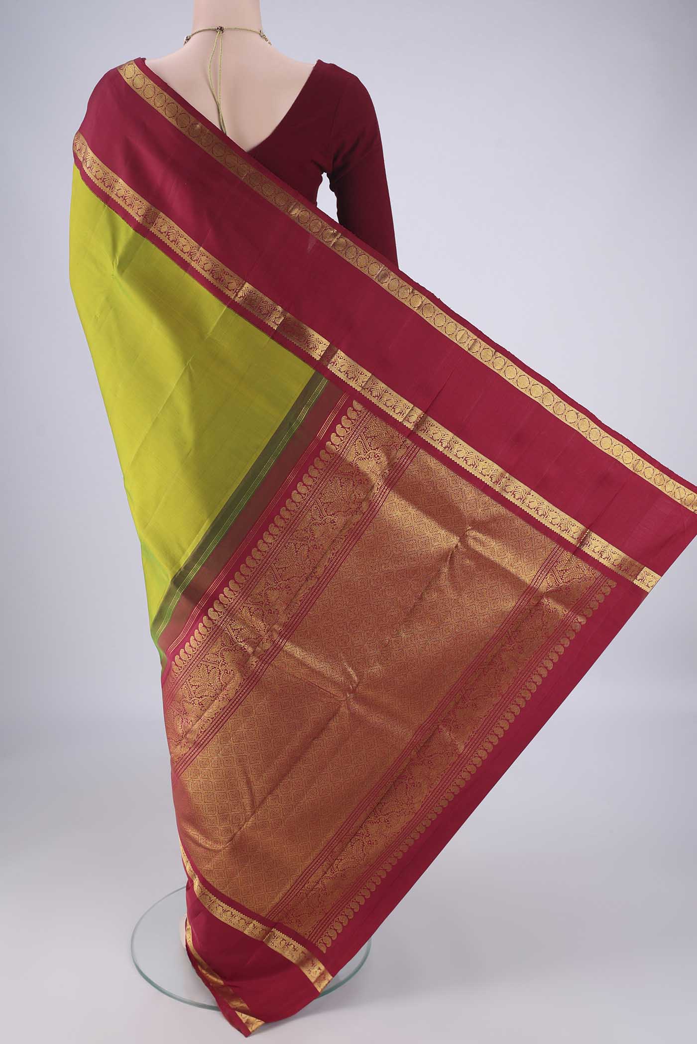 Flat view of Green Kanchipuram Silk Saree with Zari Butta on the body and Zari Border. 