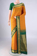 Yellow Kanchipuram Silk Saree with Zari Butta on the body and Zari Border.  displayed on a mannequin