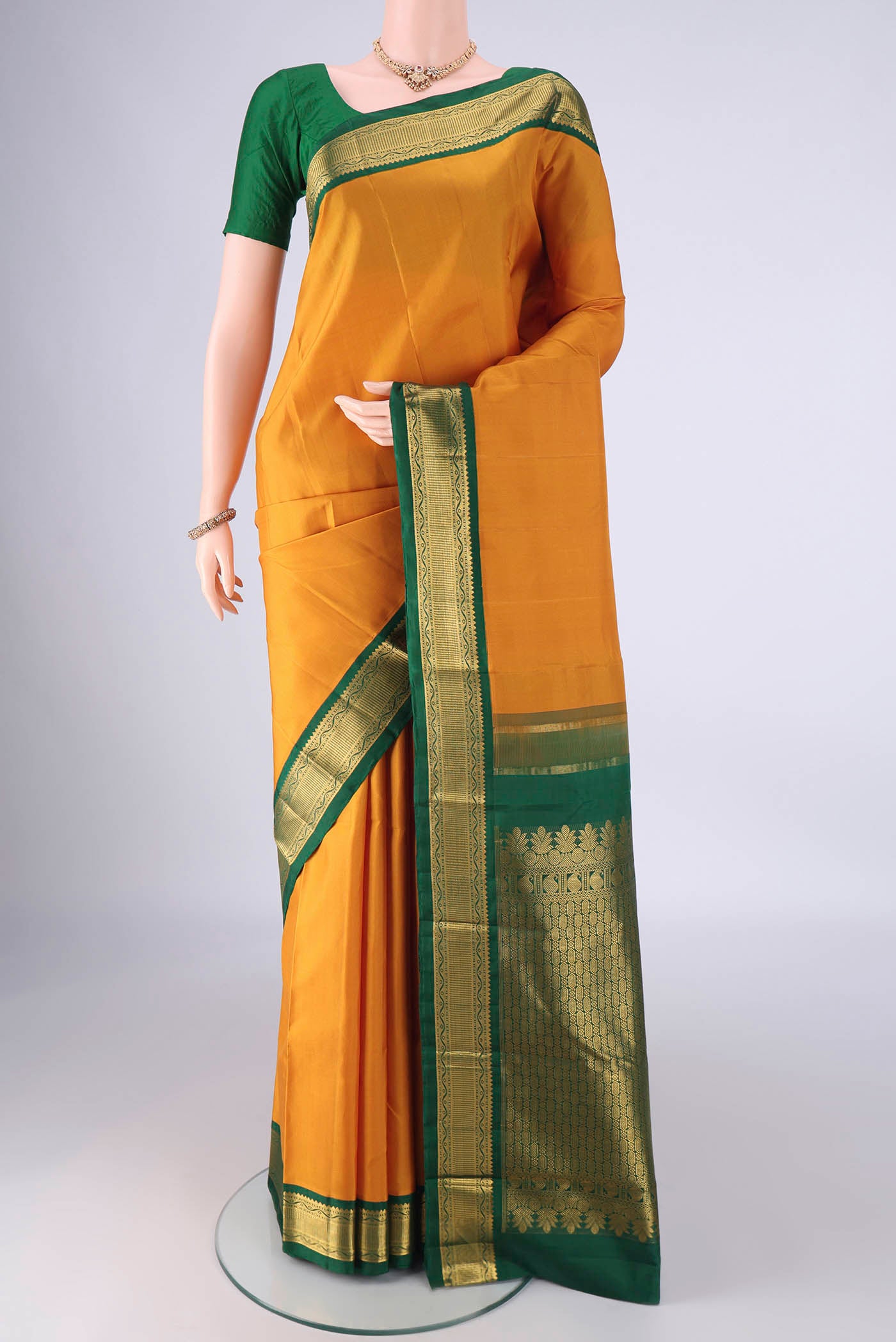 Yellow Kanchipuram Silk Saree with Zari Butta on the body and Zari Border.  displayed on a mannequin