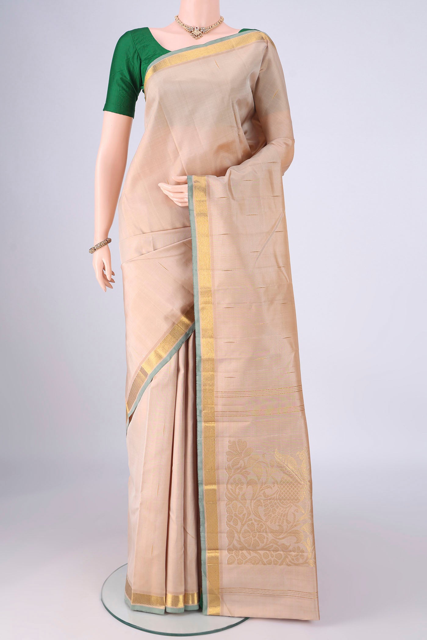 Cream Kanjivaram Silk Saree with Zari Butta on the body and Zari Border.  displayed on a mannequin