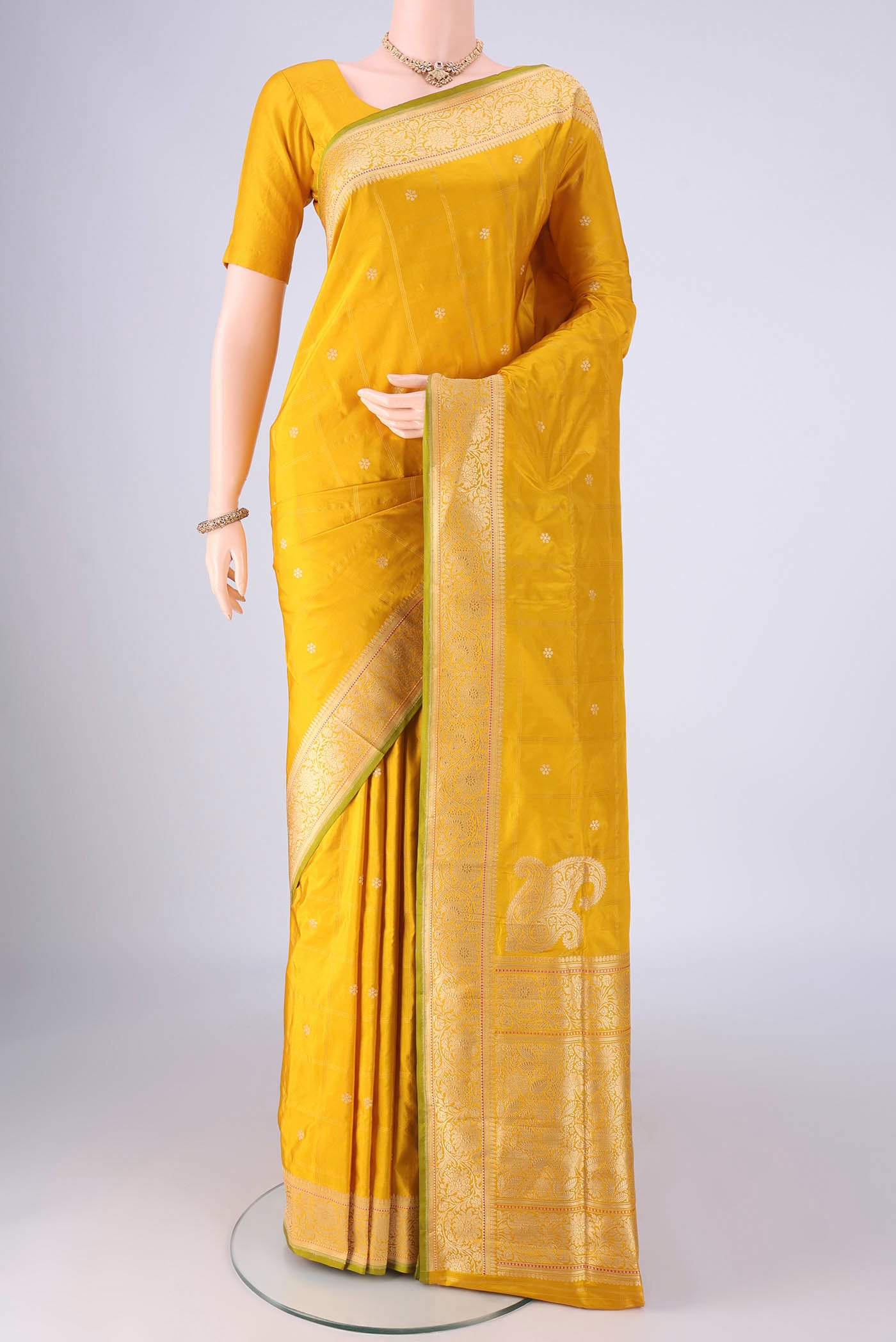 Yellow Banarasi Silk Saree with Zari Butta on the body and Zari Border.  displayed on a mannequin