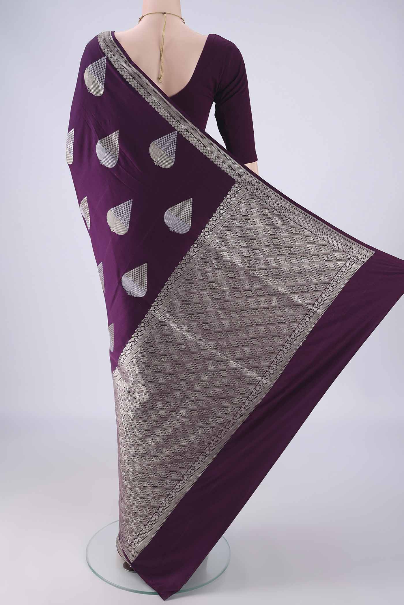 Flat view of Burgundy Banarasi Silk Saree with Zari And Thread Butta on the body and Zari Border. 