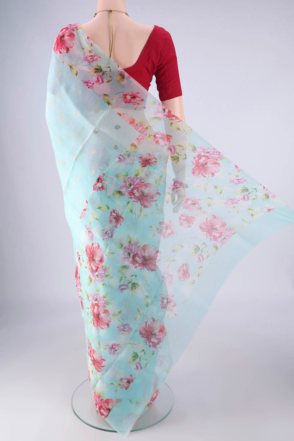 Flat view of Light Blue Organza Silk Saree with Zari Butta on the body and Printed Border. 