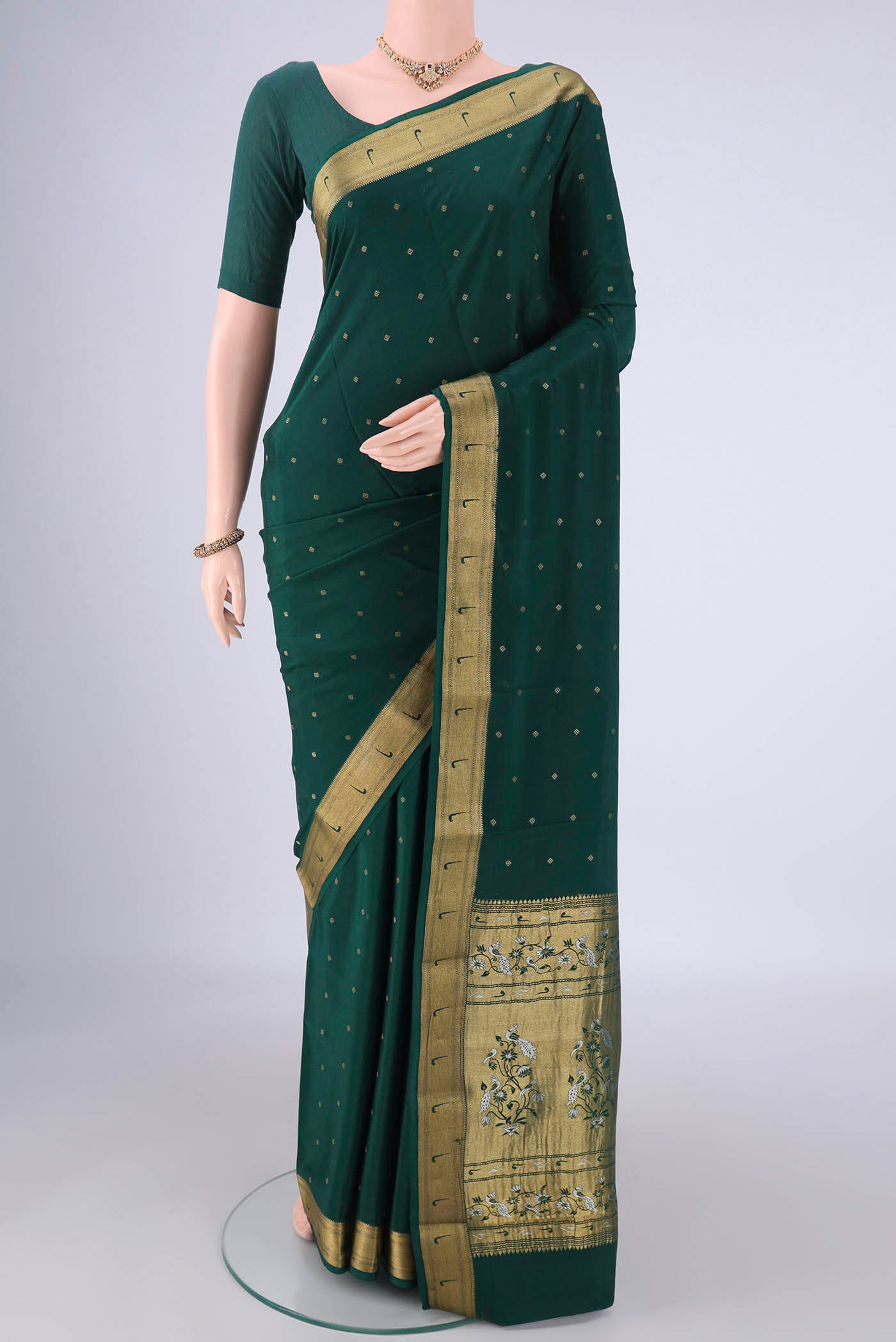 Bottle Green Mysore Crepe Saree with Zari Butta on the body and Zari Border.  displayed on a mannequin