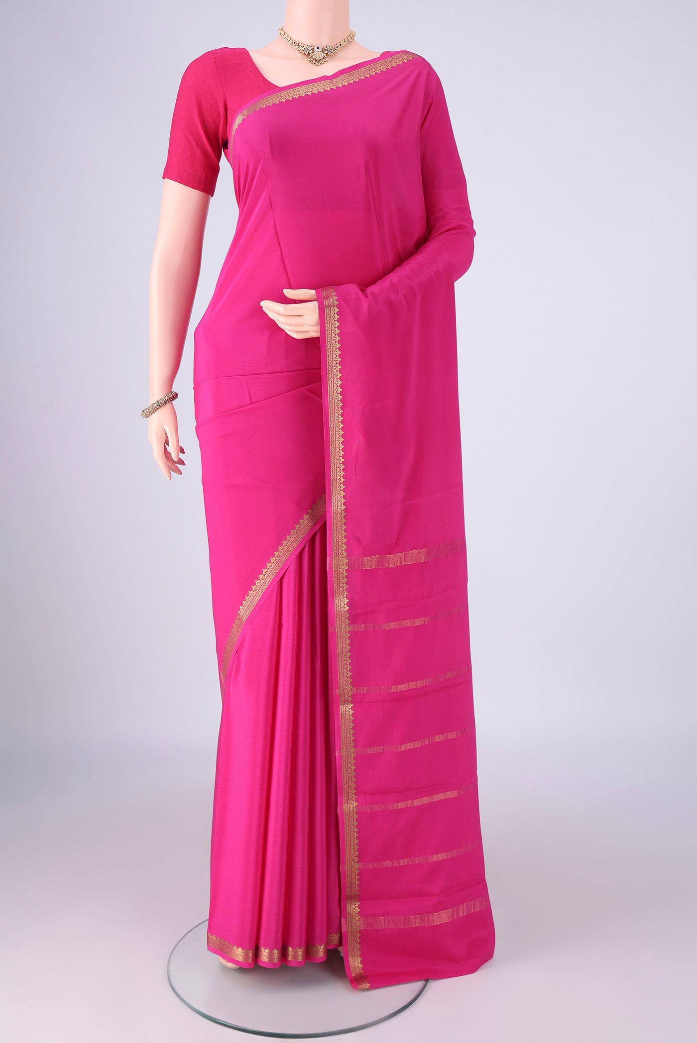 Rani Pink Mysore Crepe Saree with Plain Body and Zari Border.  displayed on a mannequin