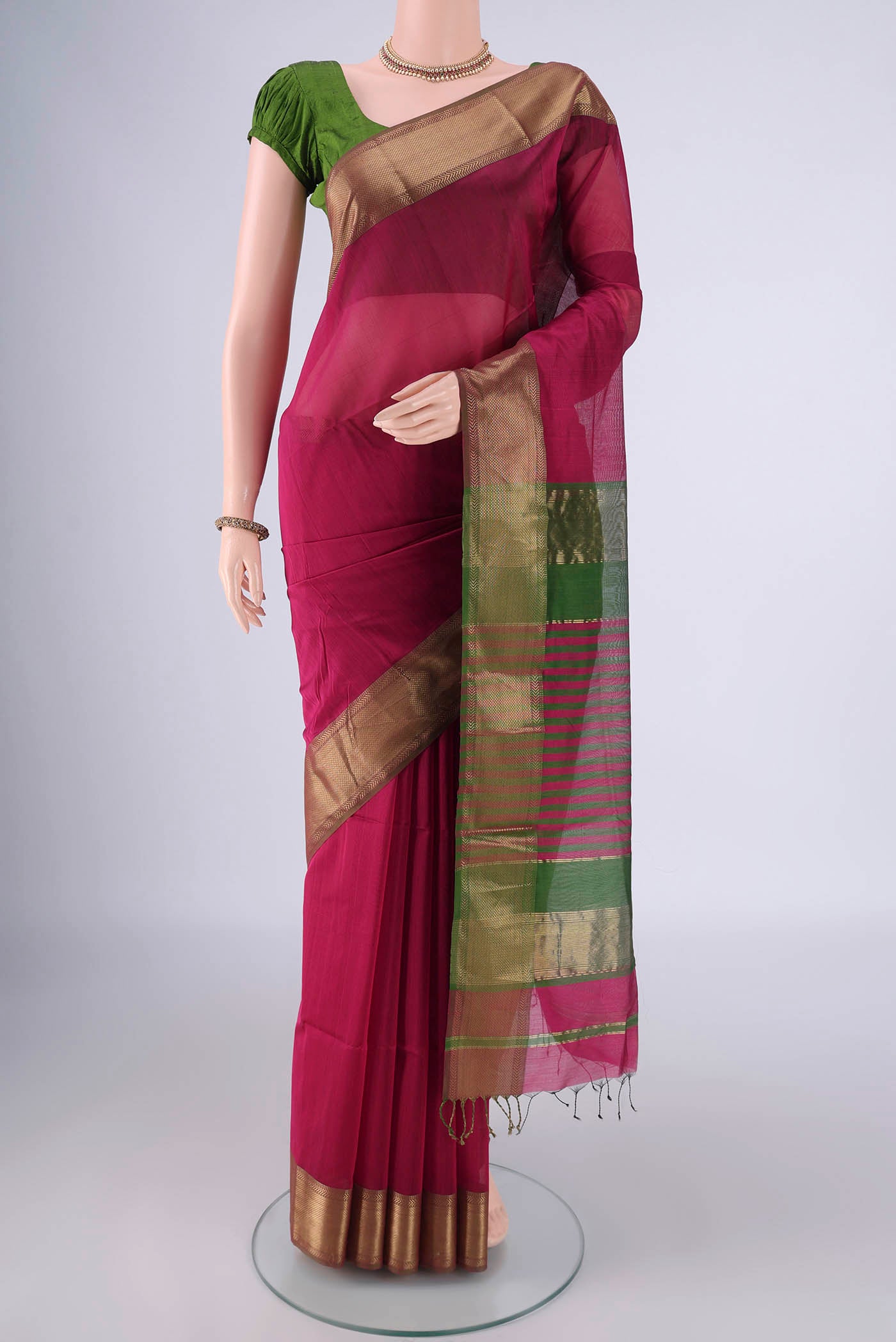 Magenta Maheshwari Silk Cotton Saree with Plain Body and Zari Border.  displayed on a mannequin