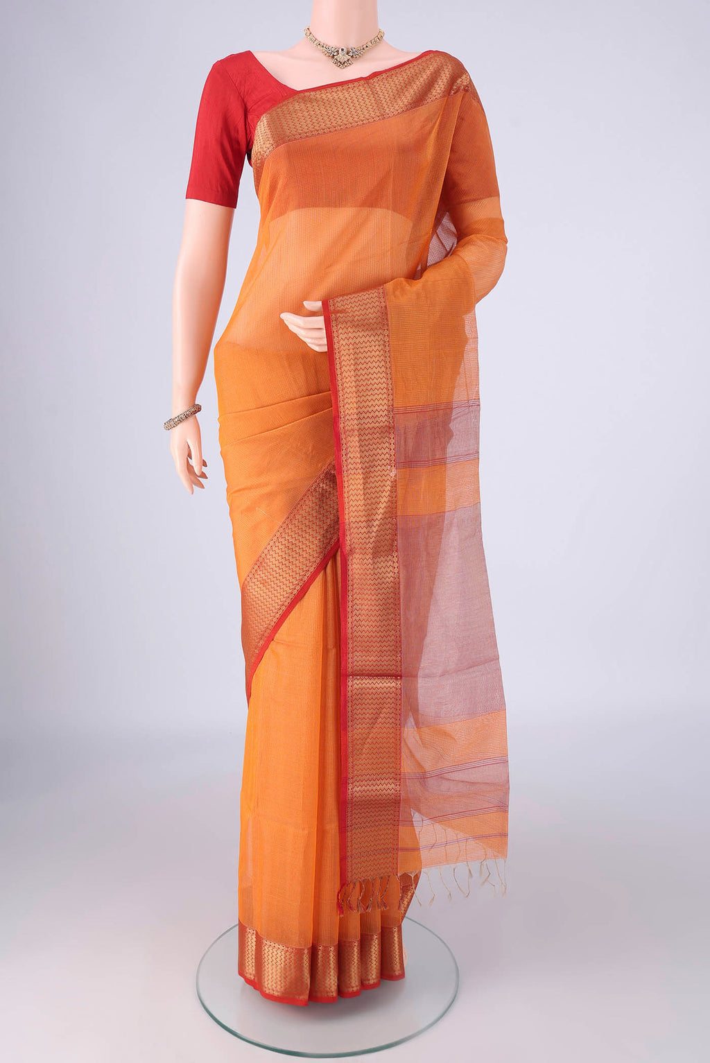 Orange Maheshwari Silk Cotton Saree with Checked design on the body and Zari Border.  displayed on a mannequin