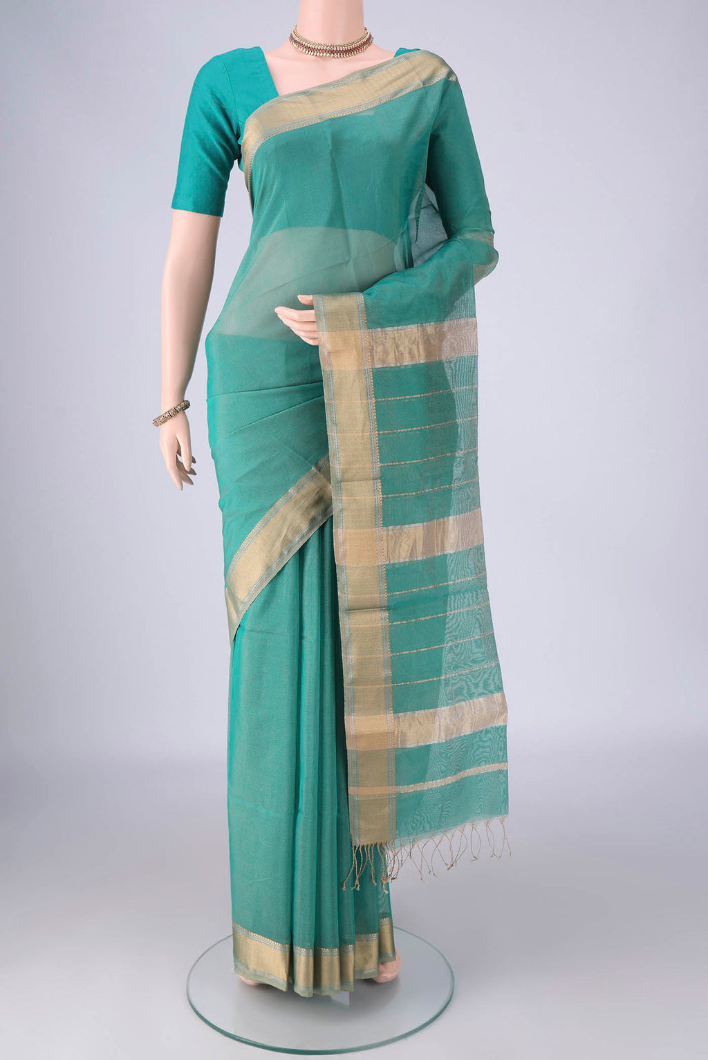 Sea Green Maheshwari Silk Cotton Saree with Stripes on the body and Zari Border.  displayed on a mannequin