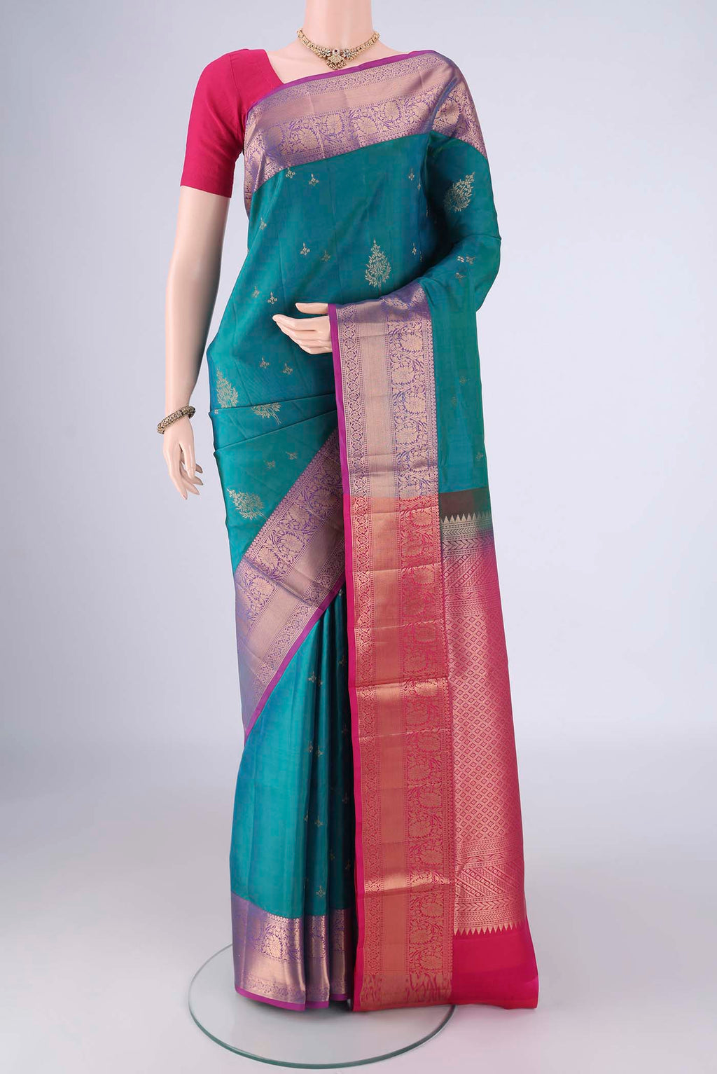 Turquoise Soft Silk Saree with Zari Butta on the body and Zari Border.  displayed on a mannequin