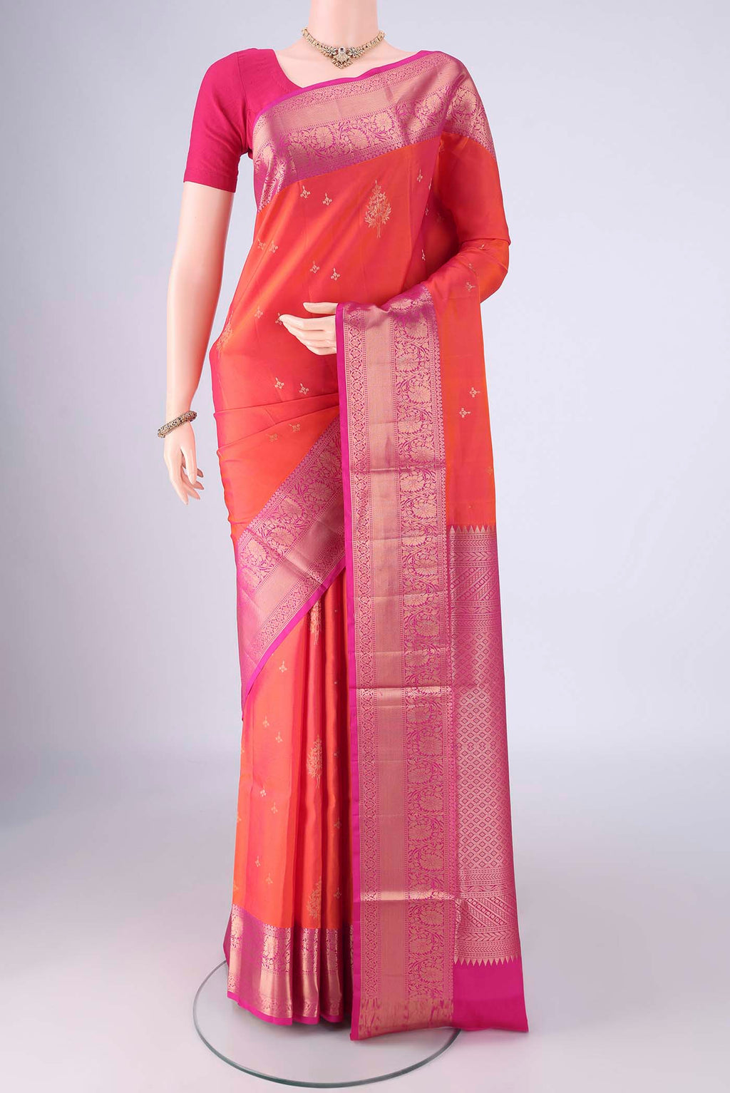 Orange Soft Silk Saree with Zari Butta on the body and Zari Border.  displayed on a mannequin