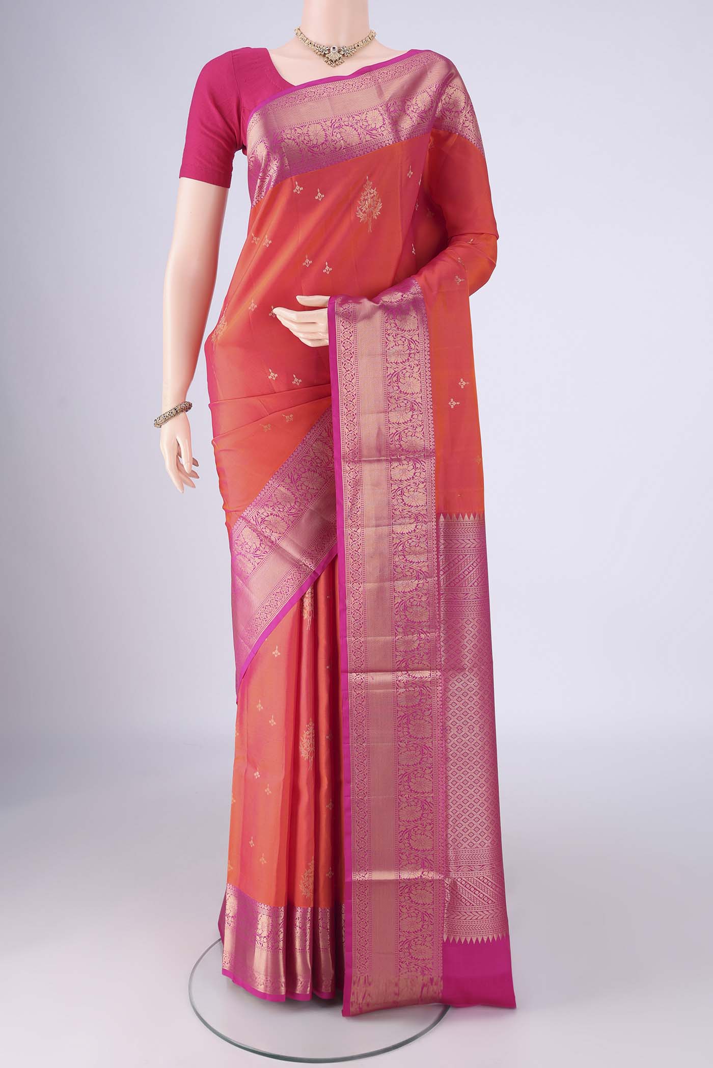 Orange Soft Silk Saree with Zari Butta on the body and Zari Border.  displayed on a mannequin