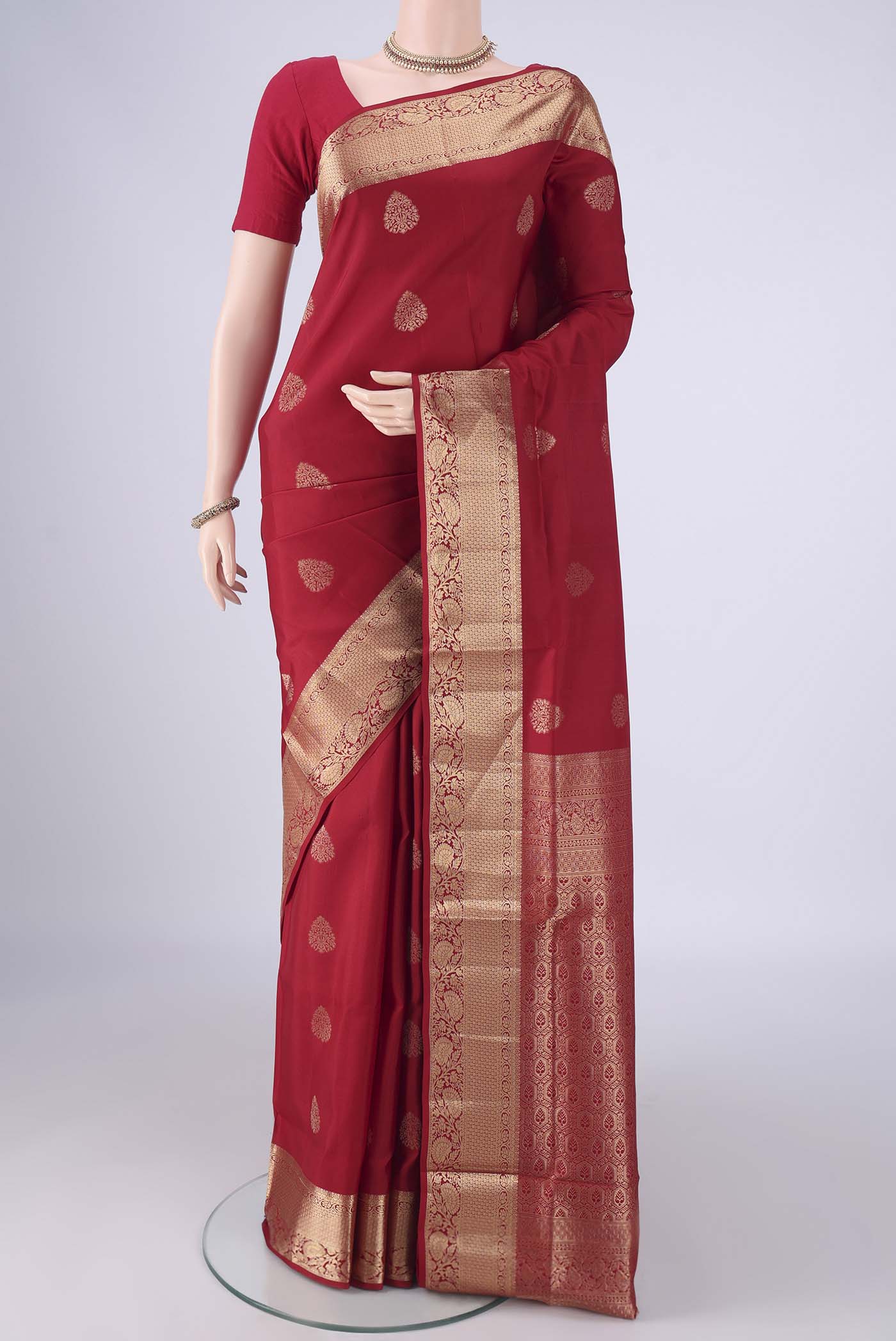 Maroon Soft Silk Saree with Zari Butta on the body and Zari Border.  displayed on a mannequin