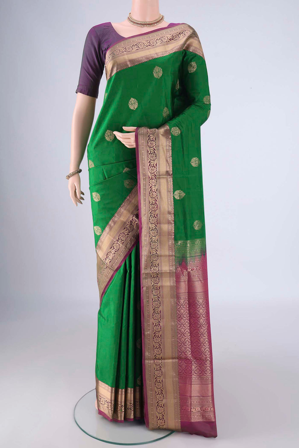 Green Soft Silk Saree with Zari Butta on the body and Zari Border.  displayed on a mannequin