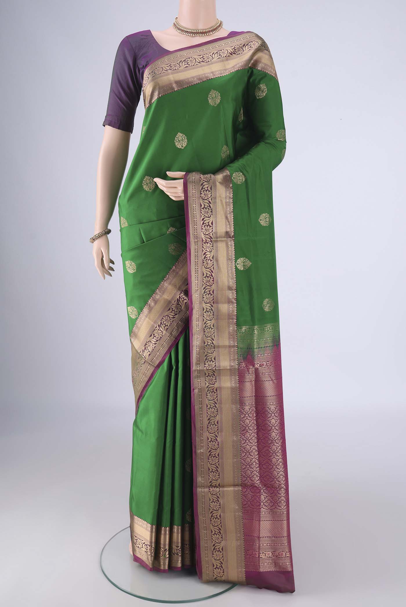 Green Soft Silk Saree with Zari Butta on the body and Zari Border.  displayed on a mannequin