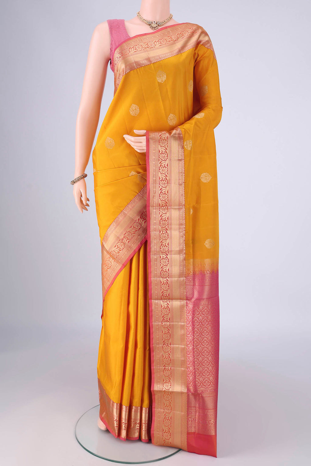 Yellow Soft Silk Saree with Zari Butta on the body and Zari Border.  displayed on a mannequin
