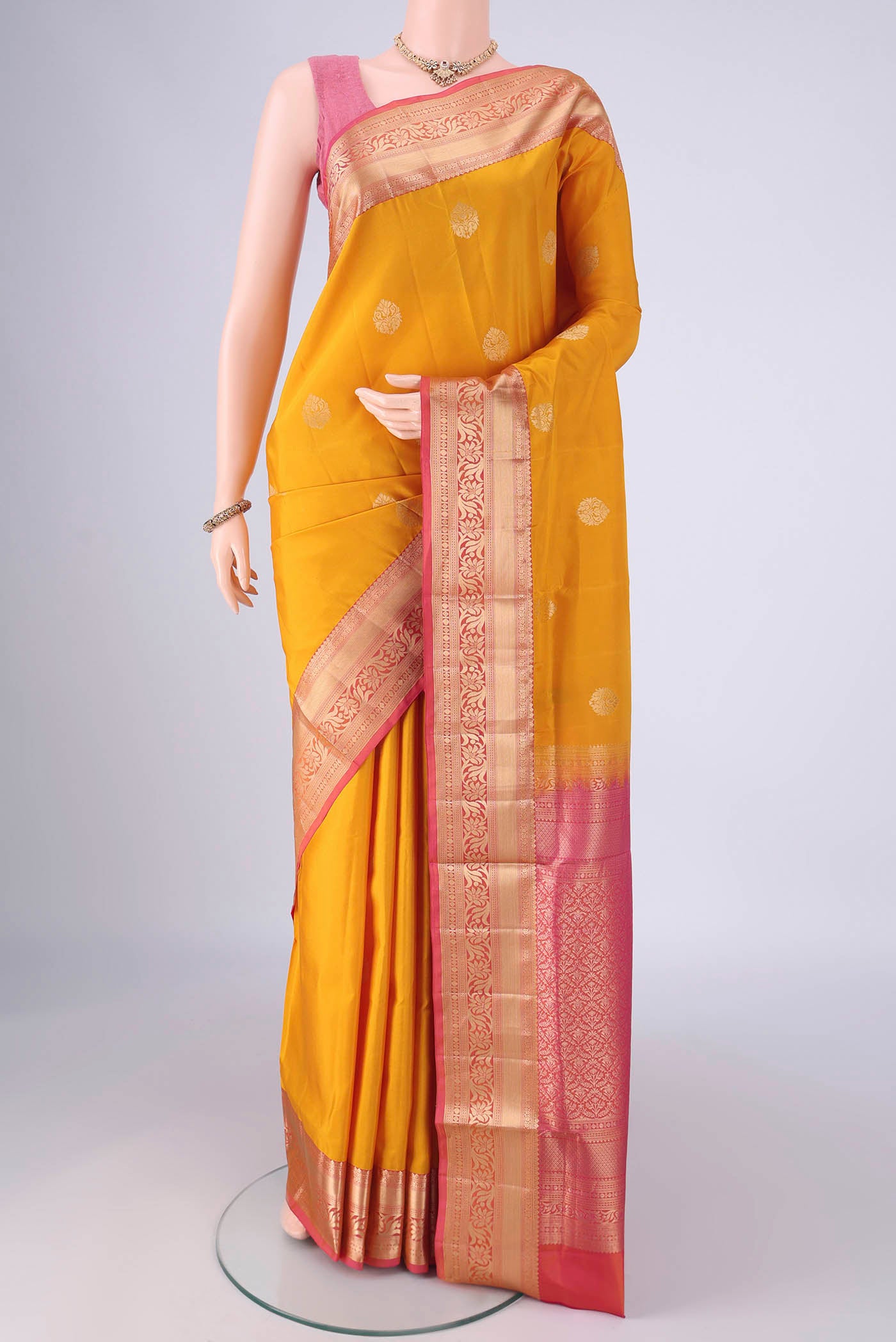 Yellow Soft Silk Saree with Zari Butta on the body and Zari Border.  displayed on a mannequin