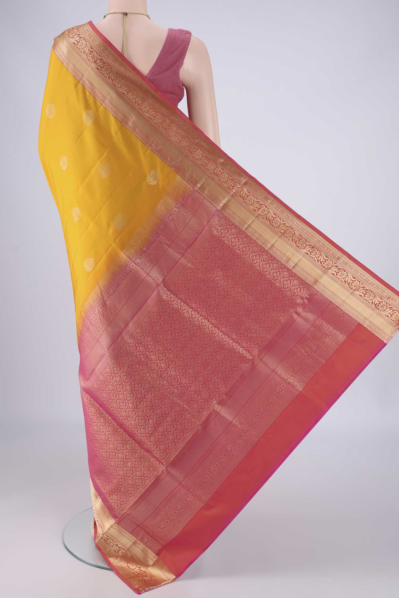 Flat view of Yellow Soft Silk Saree with Zari Butta on the body and Zari Border. 