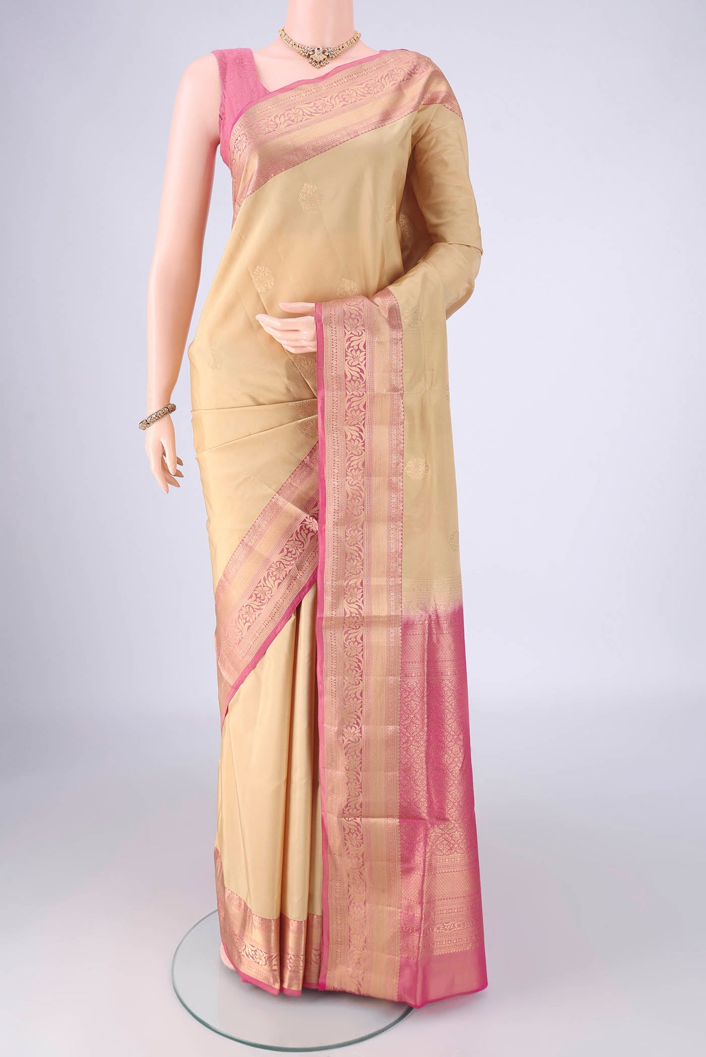 Beige Soft Silk Saree with Zari Butta on the body and Zari Border.  displayed on a mannequin