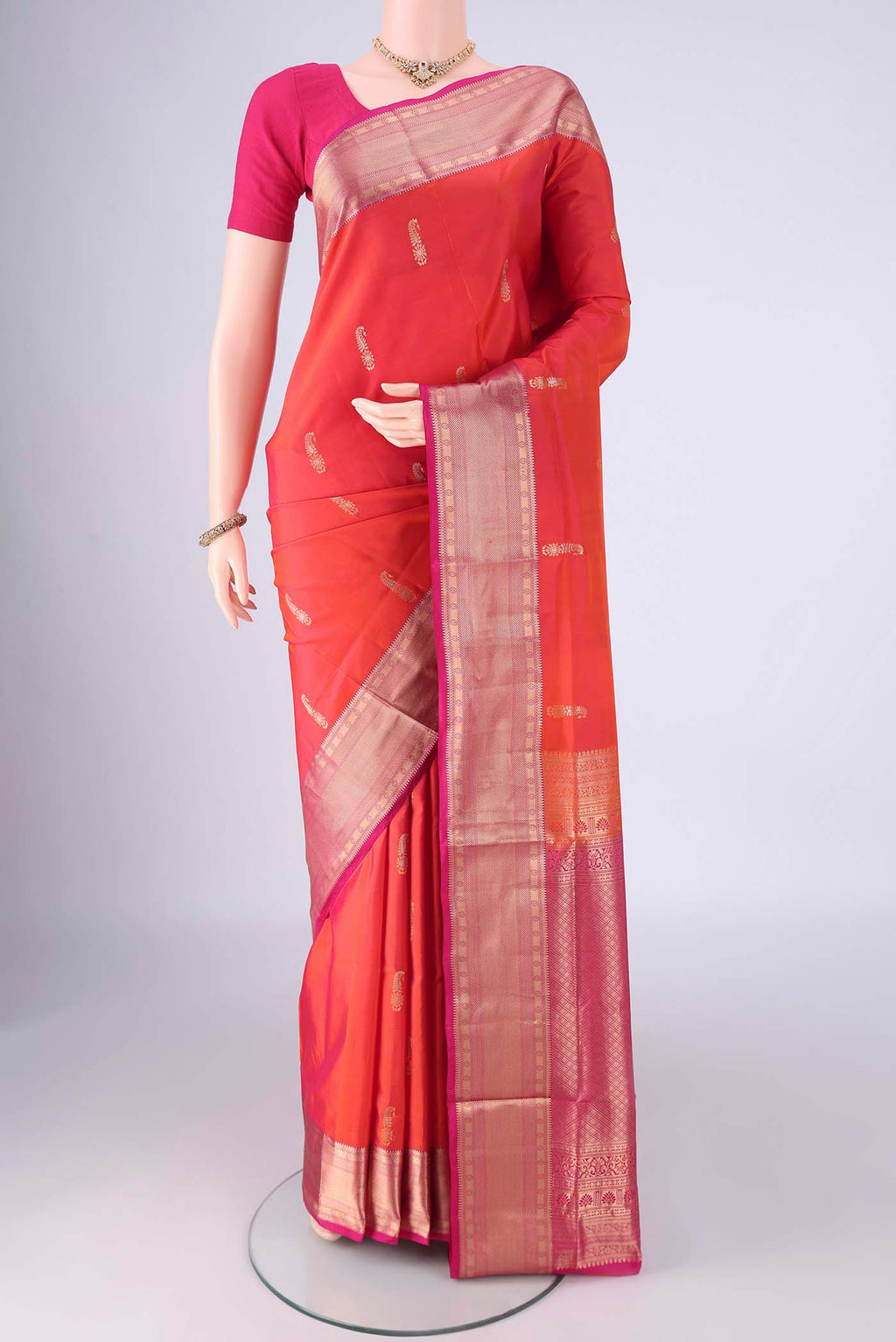Orange Soft Silk Saree with Zari Butta on the body and Zari Border.  displayed on a mannequin