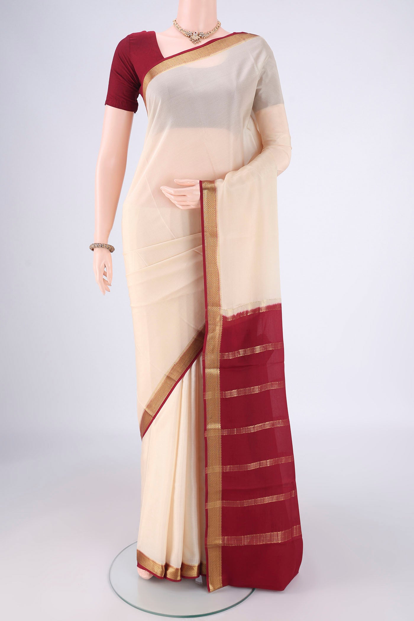 Off White Mysore Crepe Saree with Plain Body and Zari Border.  displayed on a mannequin