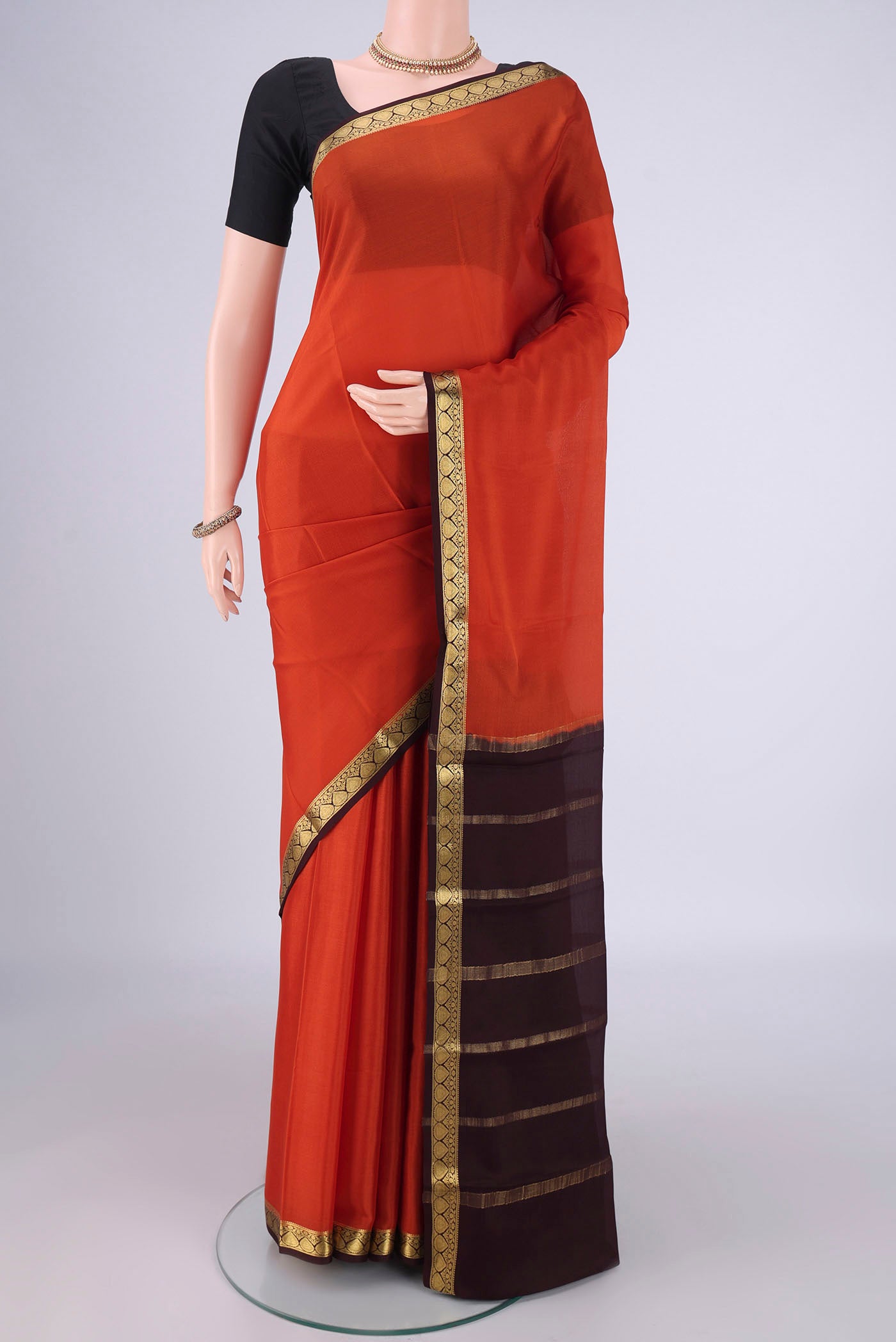 Rust Mysore Crepe Saree with Plain Body and Zari Border.  displayed on a mannequin