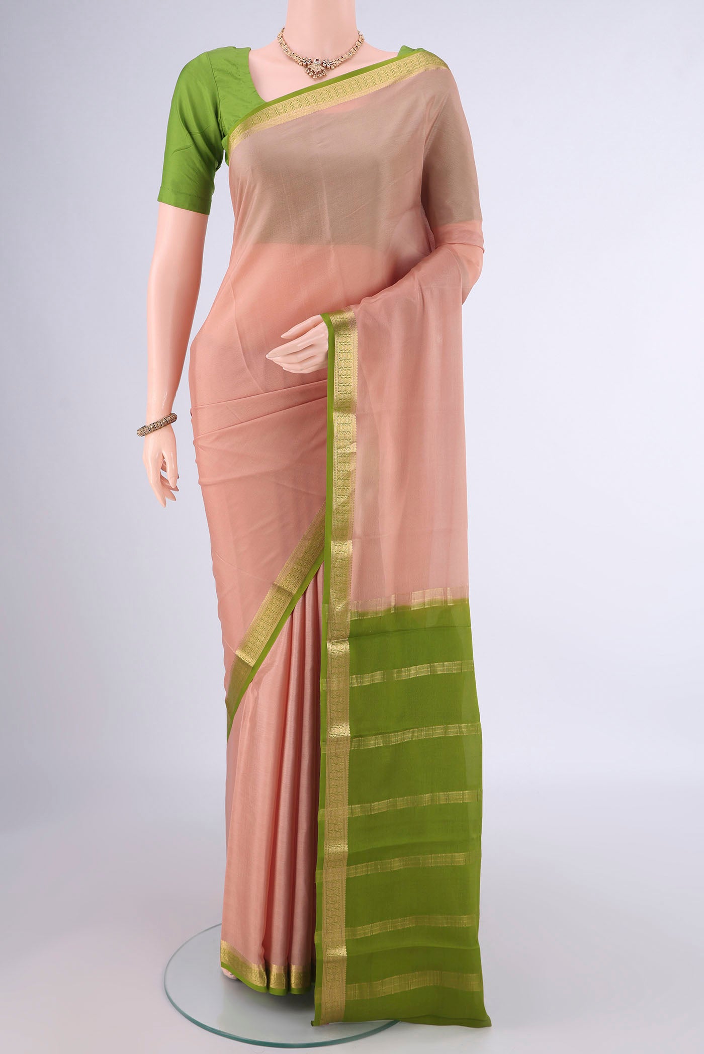 Golden Peach Mysore Crepe Saree with Plain Body and Zari Border.  displayed on a mannequin