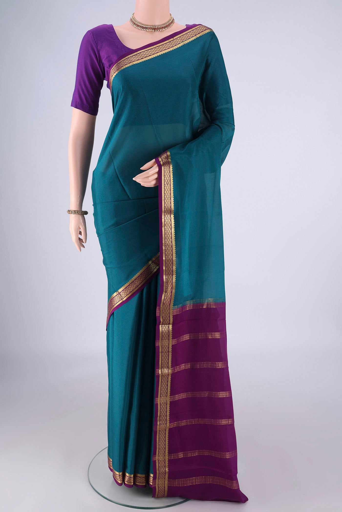 Teal Mysore Crepe Saree with Plain Body and Zari Border.  displayed on a mannequin