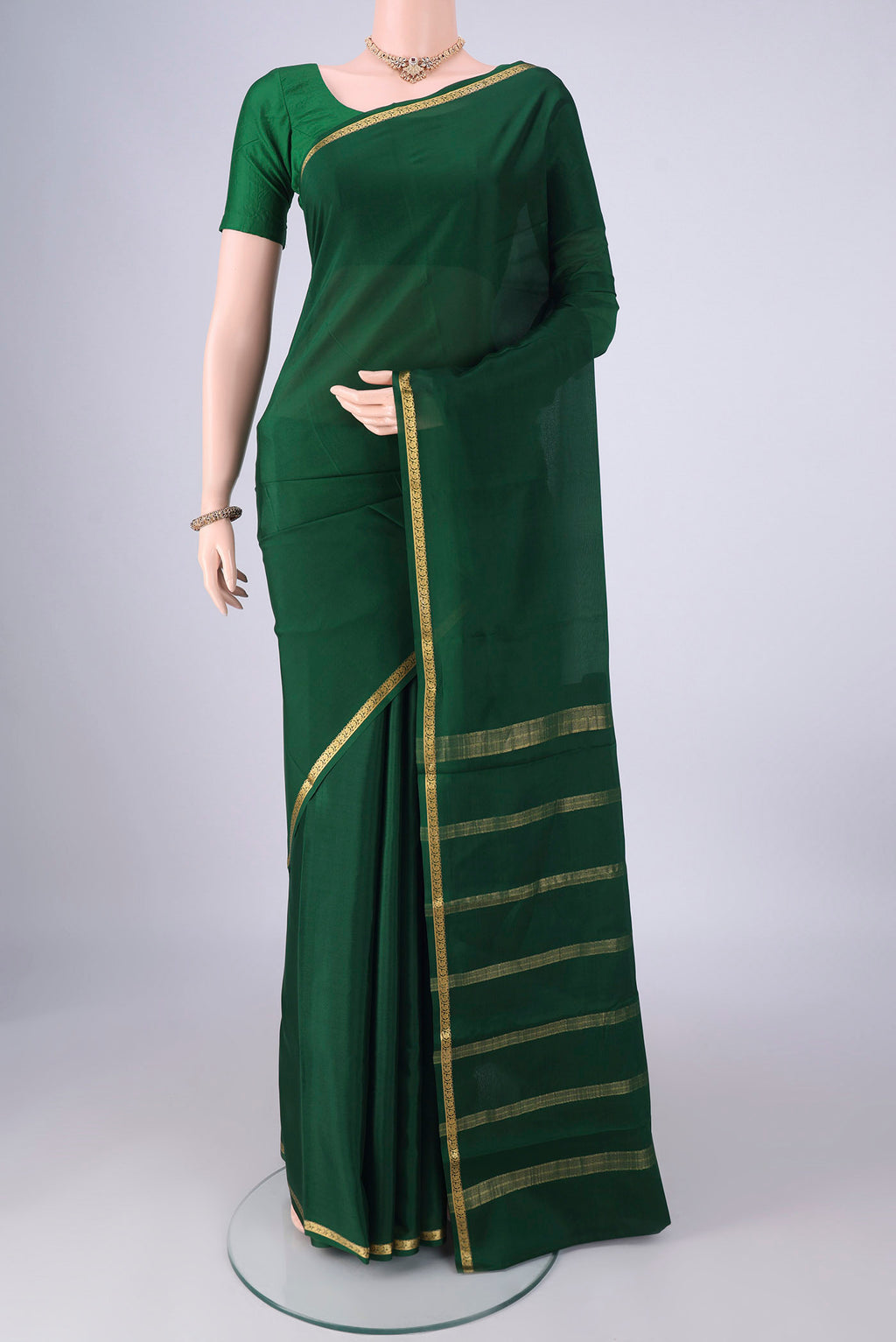 Bottle Green Mysore Crepe Saree with Plain Body and Zari Border.  displayed on a mannequin