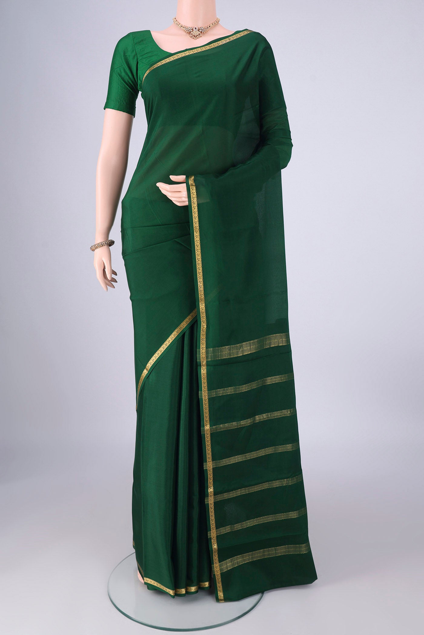 Bottle Green Mysore Crepe Saree with Plain Body and Zari Border.  displayed on a mannequin